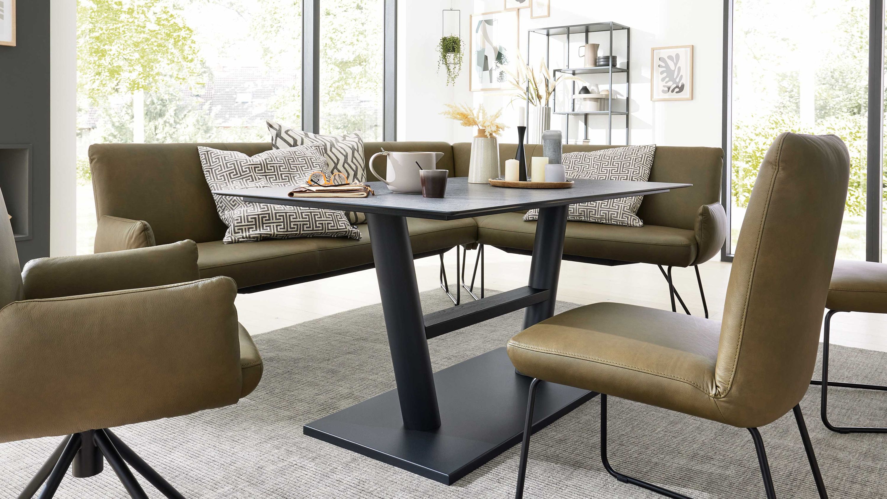 Rechteckiger Esstisch mit betonfarbener Tischplatte und schwarzem Metallgestell in modernem Esszimmer