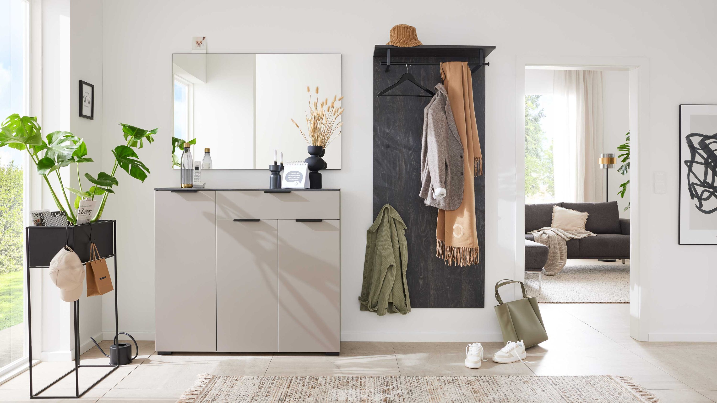 Dreiteiliges Garderoben-Set mit graubeiger Kommode großem Spiegel und dunklem Wandpaneel mit Hutablage und Haken