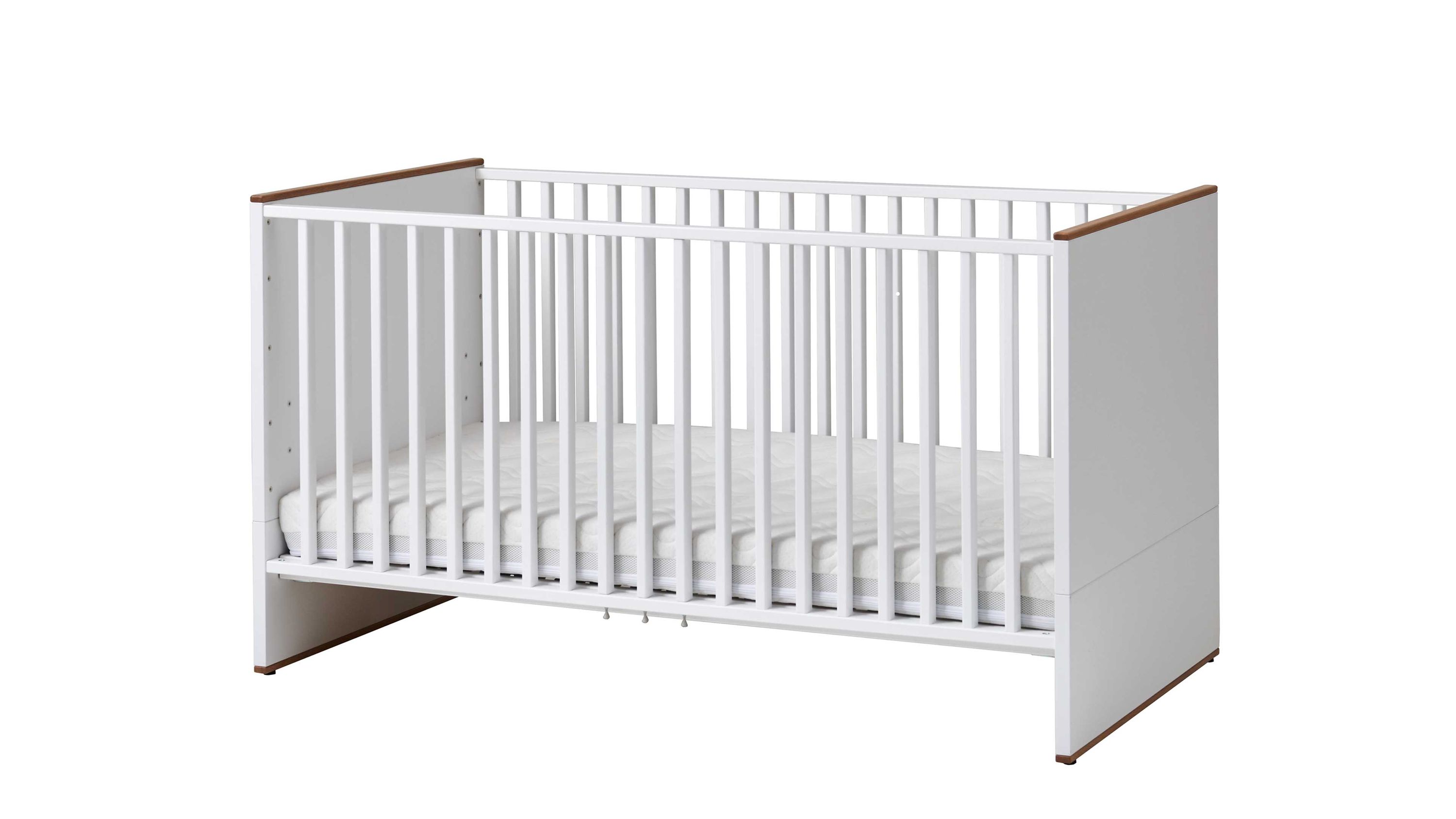 Babybettgestell in weiß mit seitlichen Gitterstäben und braunen Akzenten an den Ecken