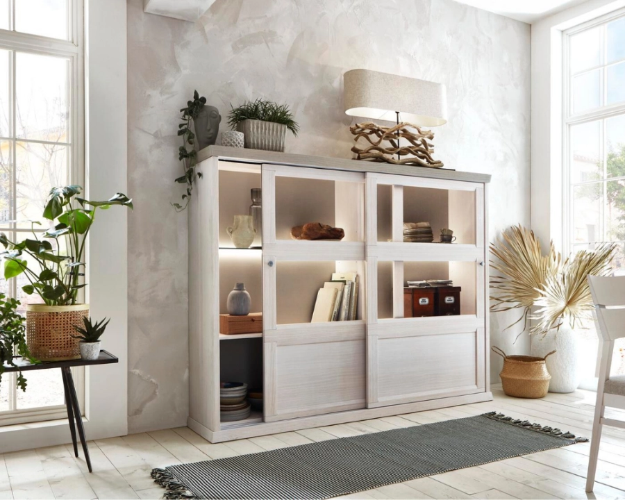 Dekorative Kommode mit Pflanzen und stilvollen Accessoires im modernen Wohnambiente Weiße Kommode mit Pflanzen, Vasen und Dekoobjekten, modern arrangiert vor hellem Hintergrund