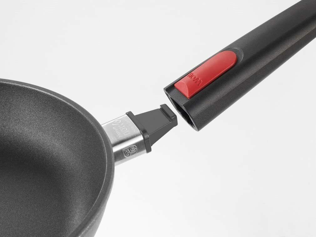 Detailaufnahme des schwarzen Griffs mit rotem Knopf an runder Gusspfanne