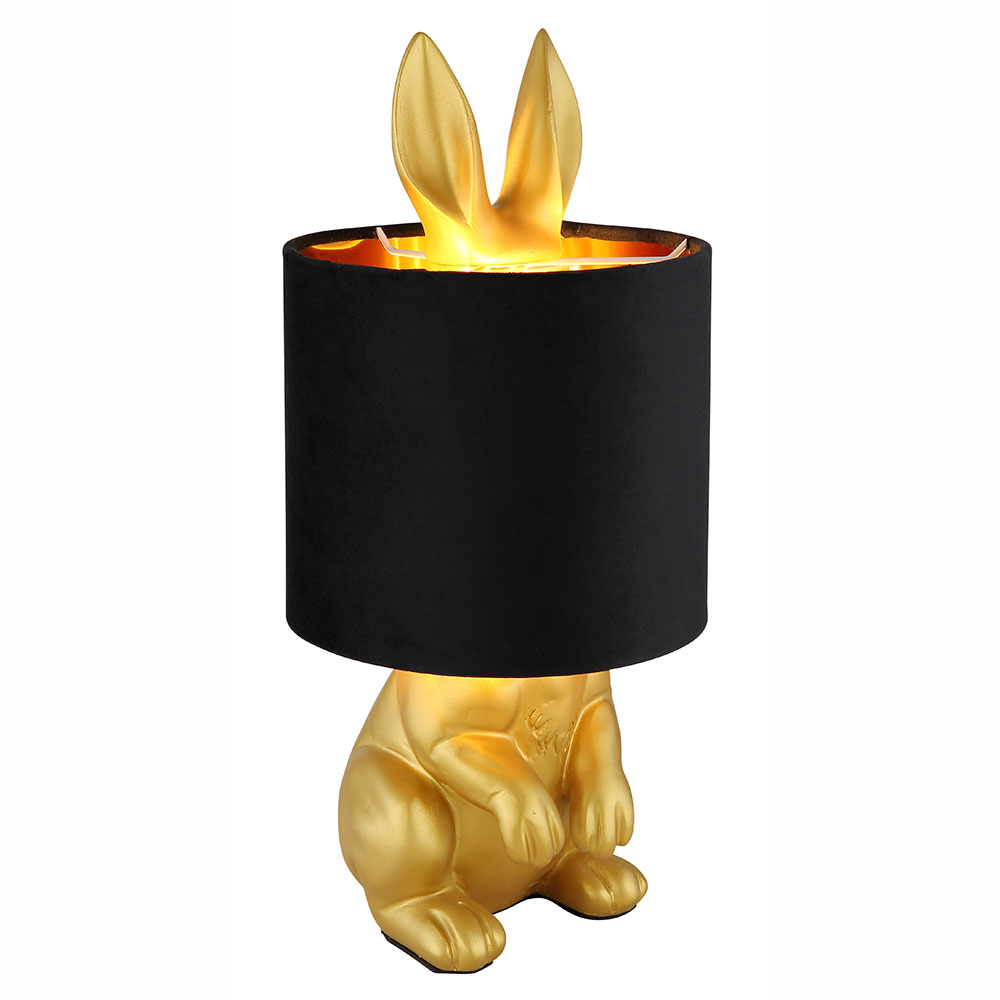 Goldene Hasen-Tischleuchte mit schwarzem Schirm Goldfarbene Hasen-Tischleuchte mit schwarzem Schirm Ohren ragen heraus schräg von links aufgenommen