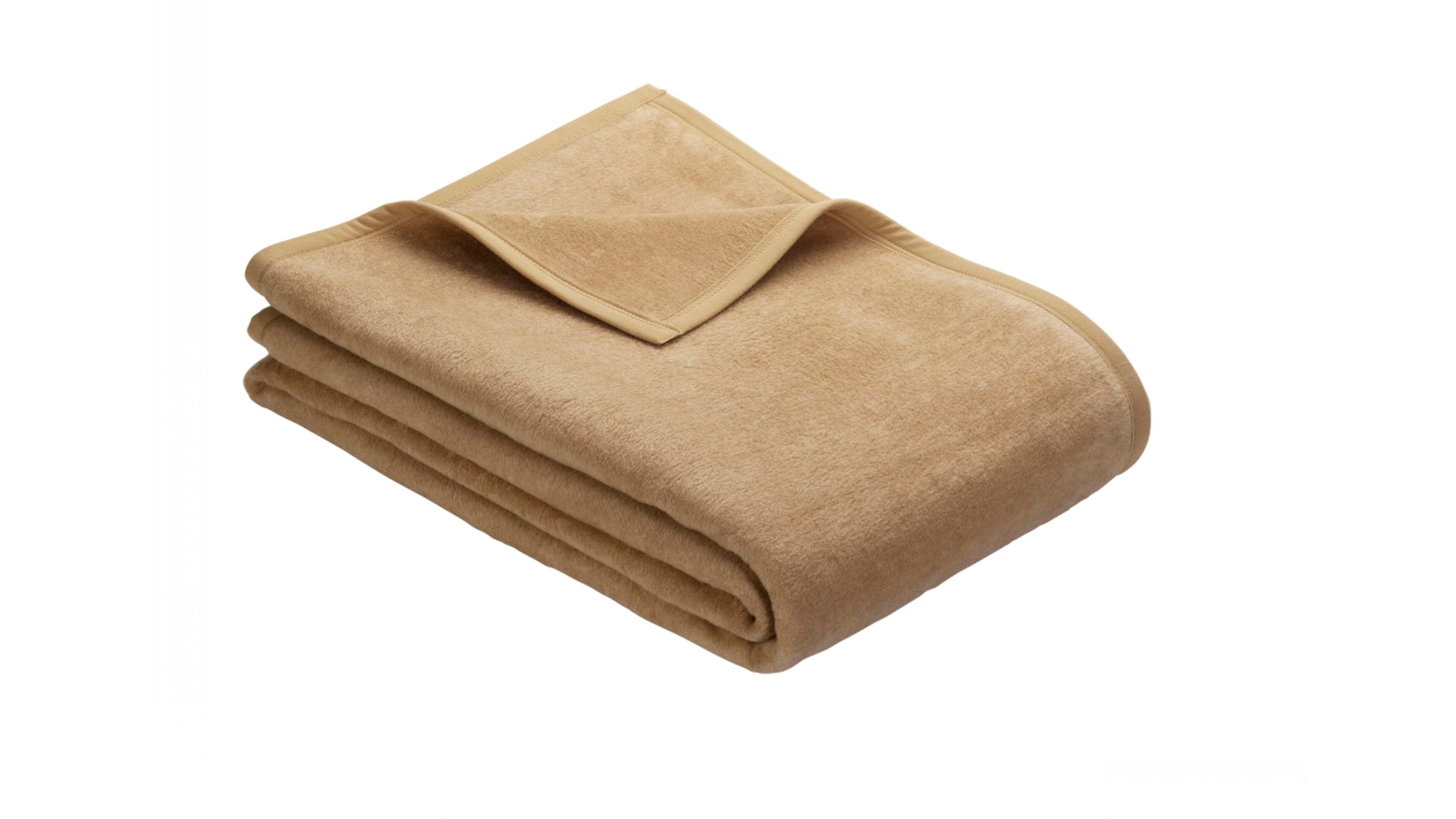 Gefaltete Fleecedecke in camelfarben mit eingefasstem Rand