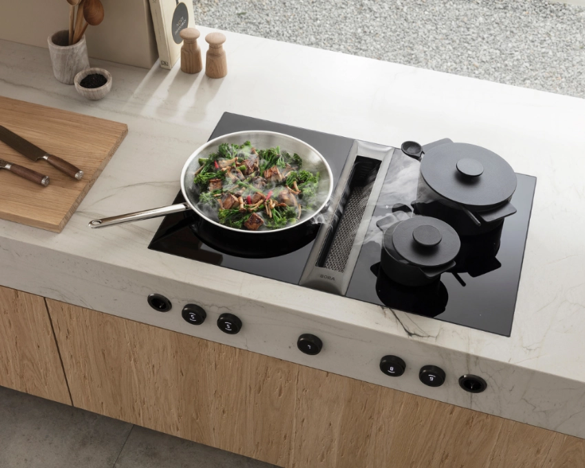 Kochbereich mit Salatschüssel und Bora Classic Helle Küche mit eingebautem Bora Kochfeld, Topf und servierfertigem Salat auf Arbeitsfläche