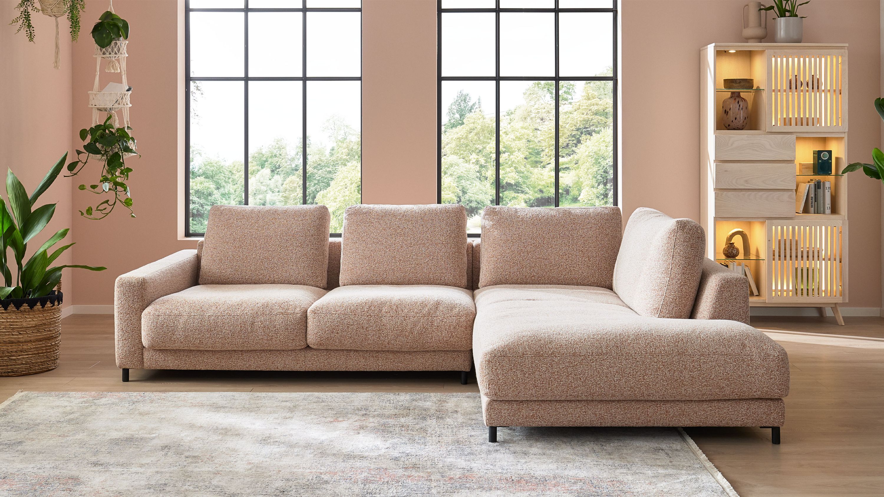Ecksofa mit rostfarbenem meliertem Bezug und Metallfüßen Ecksofa mit meliertem Bezug in rostfarben und Metallfüßen in einem hellen Wohnzimmer