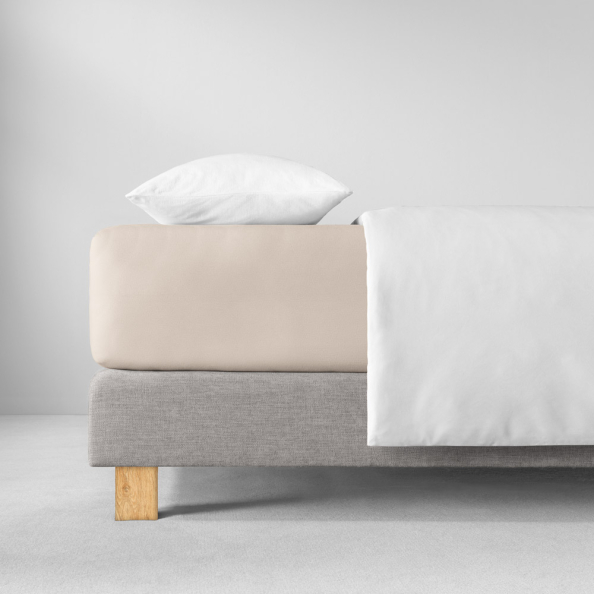 Bett mit ecrufarbenem Spannbetttuch  weißem Kissen und Decke, grauer Rahmen mit Holzfüßen