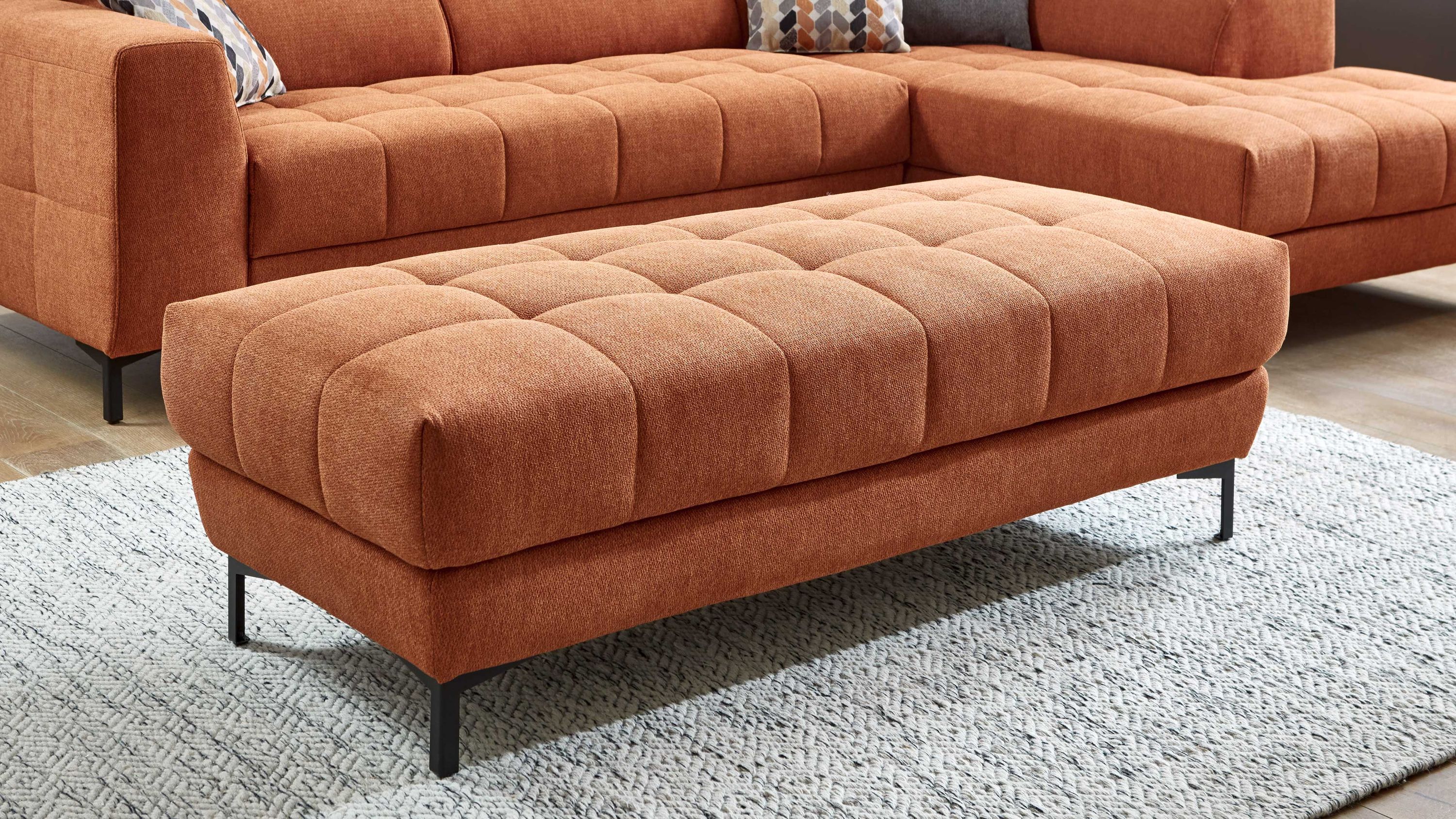 Großer rechteckiger Polsterhocker in orange mit gestepptem Bezug und schwarzen Metallfüßen