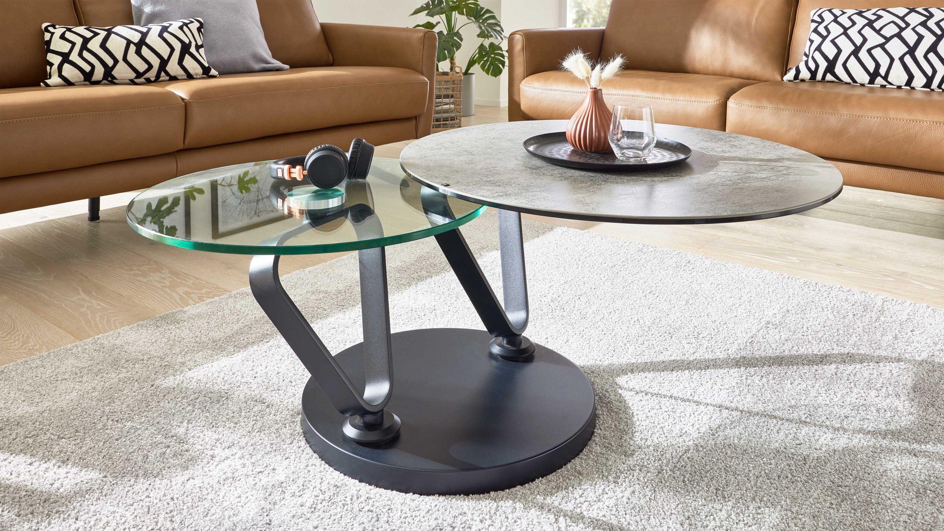 Runder Couchtisch mit zwei unterschiedlich hohen Tischplatten eine silbergrau eine transparent schwarzer runder Sockel