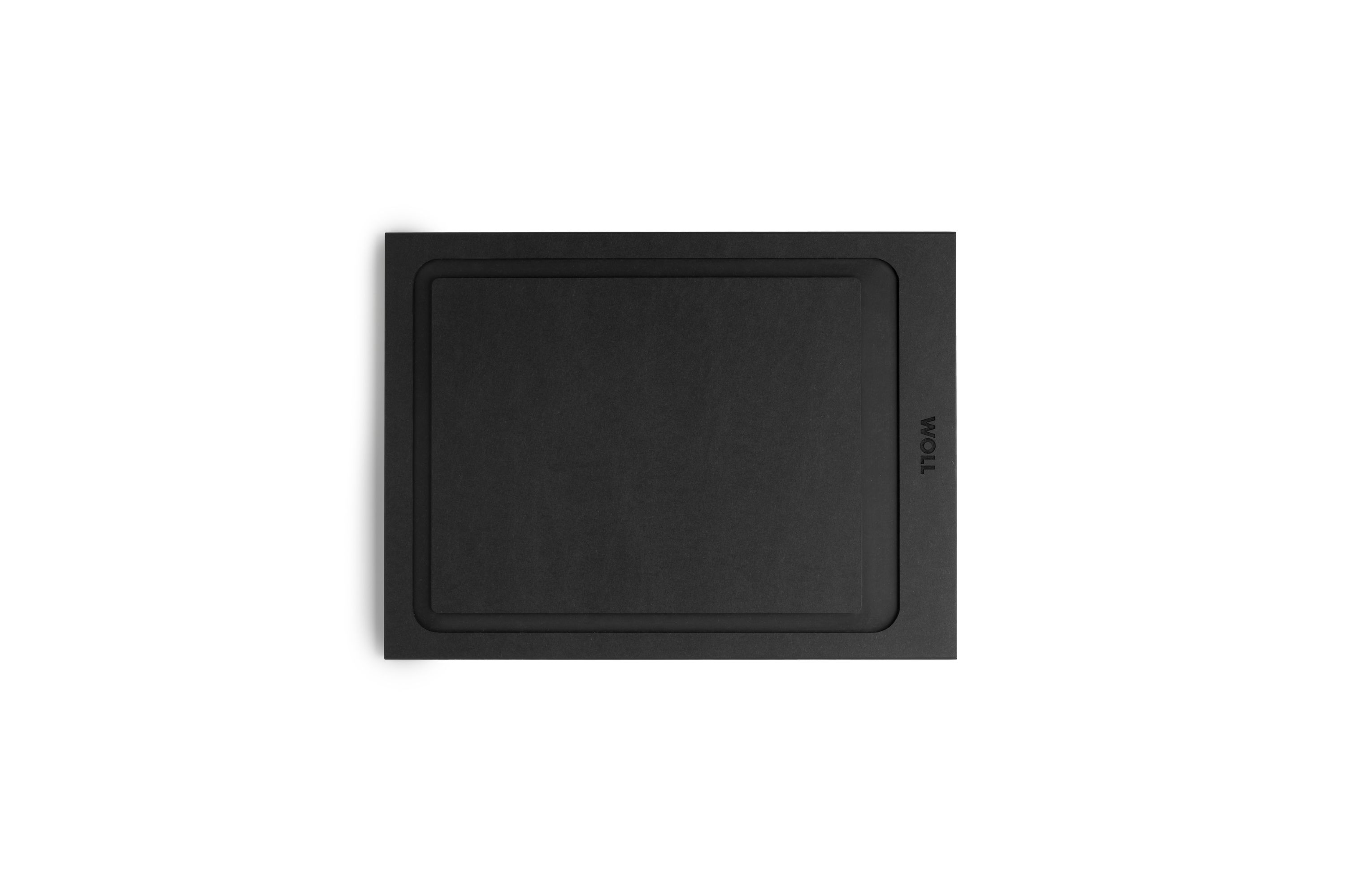 Draufsicht auf schwarzes WOLL-Schneidebrett mit funktionalem Design. WOLL-Schneidebrett in Schwarz, rechteckig mit abgerundeter Vertiefung, von oben fotografiert.