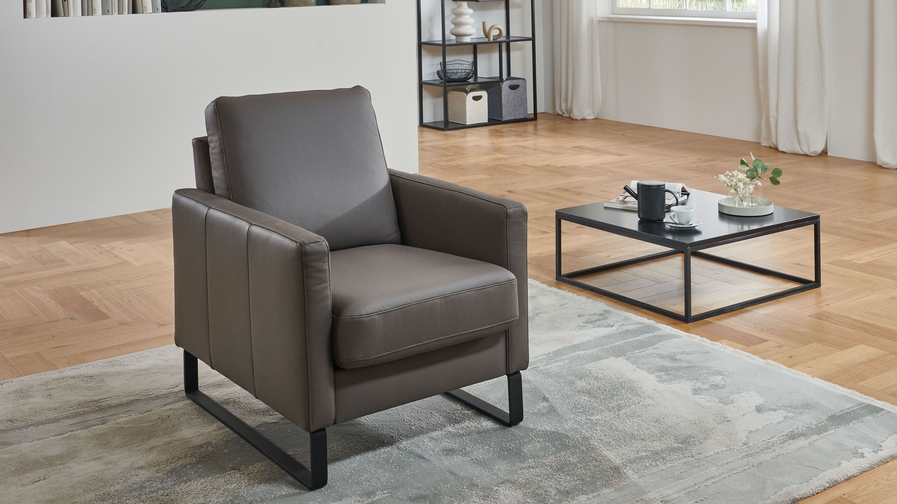 Sessel mit geraden Armlehnen und Metallgestell in elefantgrauer Farbe in modernem Wohnzimmer