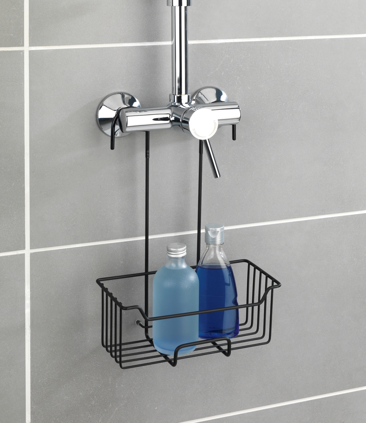 Duschkorb mit Flaschen an Wandhalterung Duschkorb mit zwei Flaschen, aufgehängt an einer Duschhalterung vor gefliester Wand, frontal fotografiert.