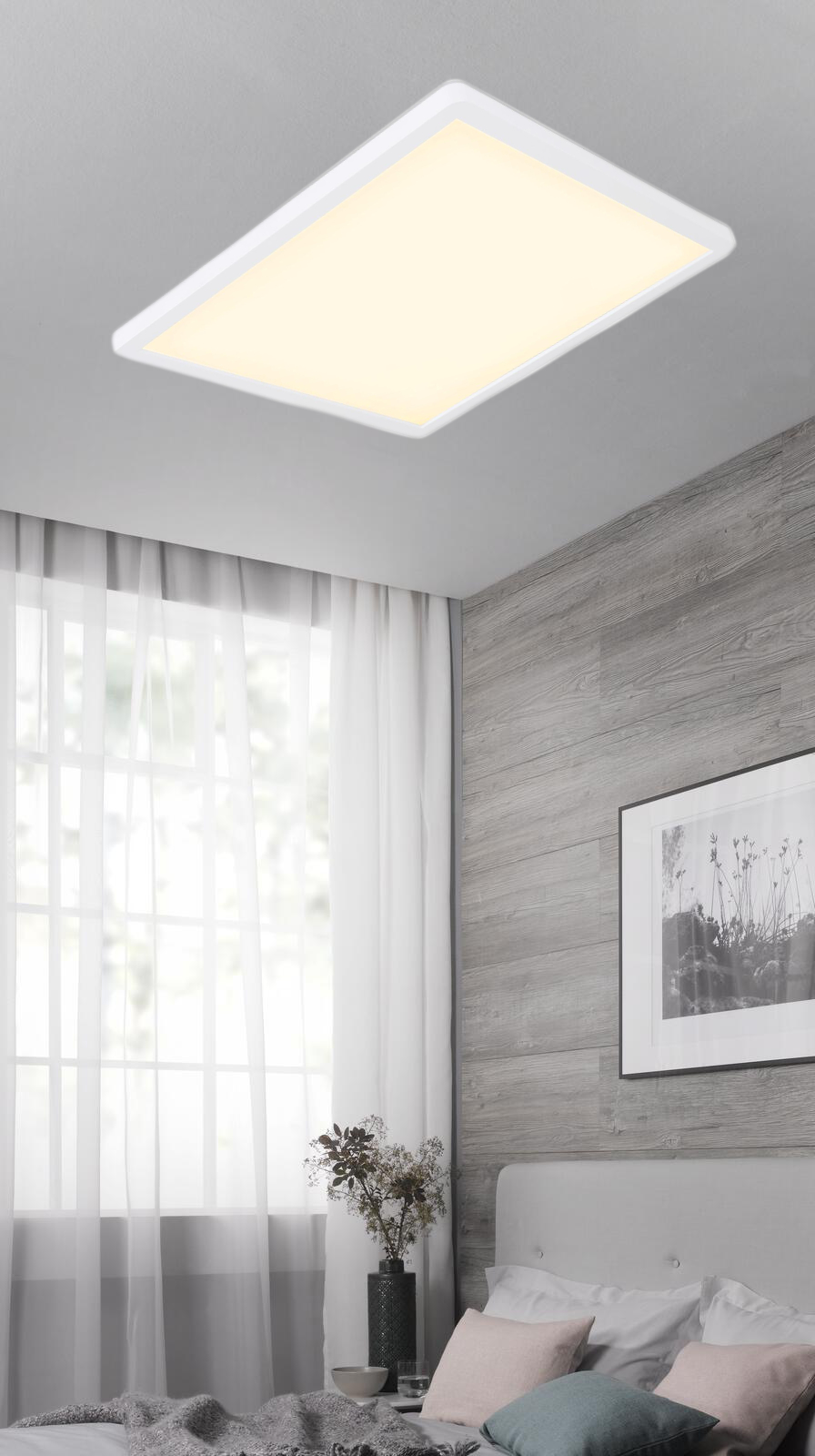 Rechteckige LED-Deckenleuchte mit matter Lichtfläche mittig an heller Zimmerdecke  in modernem Schlafzimmer fotografiert