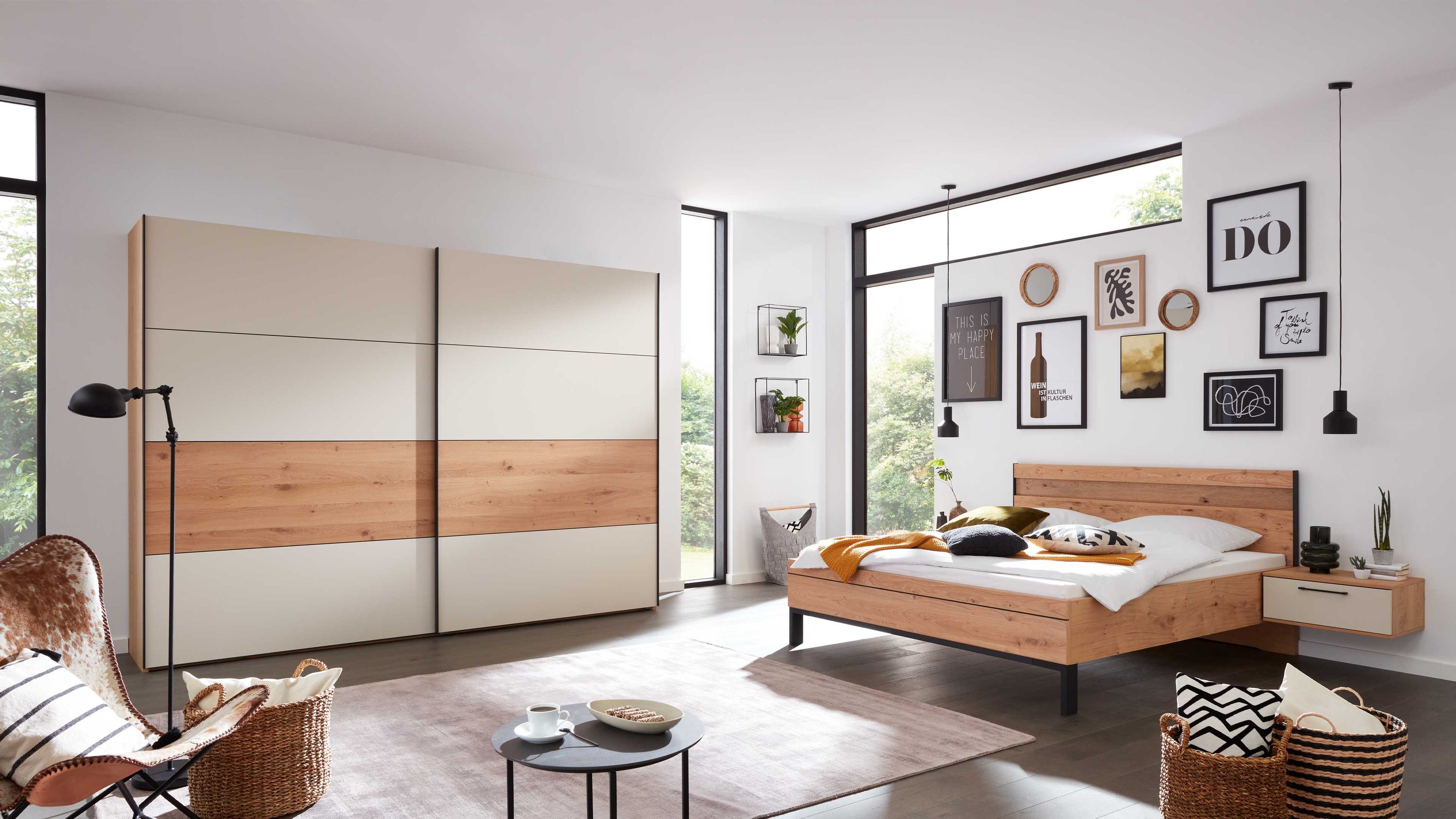 Schlafzimmer mit Bett und Schrank in Sand und Balkeneiche Schlafzimmer mit Bett Nachttisch und großem Schiebetürenschrank in hellen und holzfarbenen Tönen