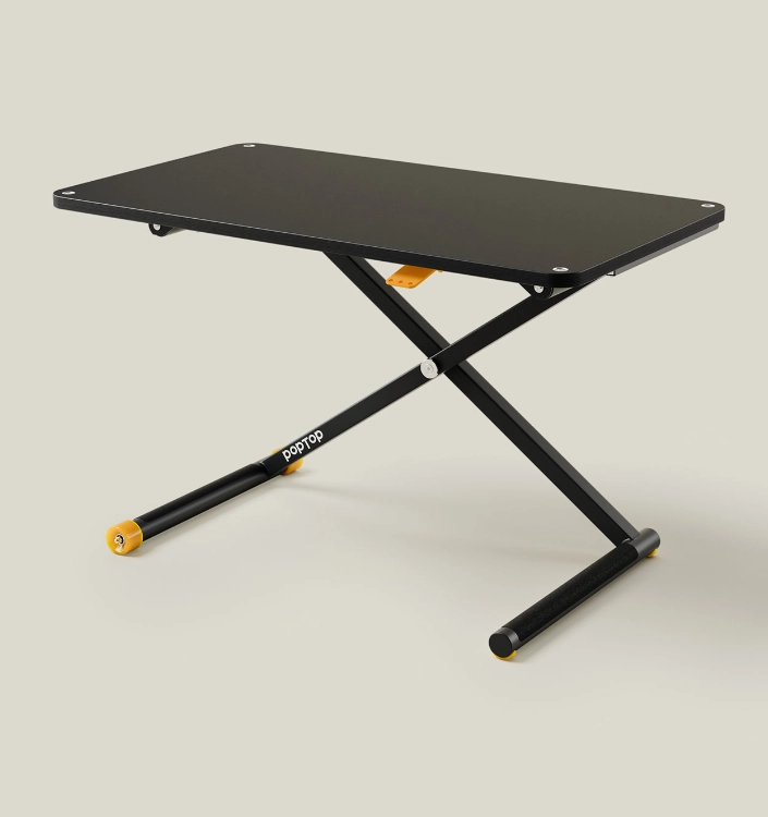 Poptop Schreibtisch schwarz Schwarzer multifunktionaler Tisch mit klappbarem X-Gestell und gelben Akzenten, flexibel einsetzbar als Beistelltisch, Arbeitstisch oder Spieltisch.