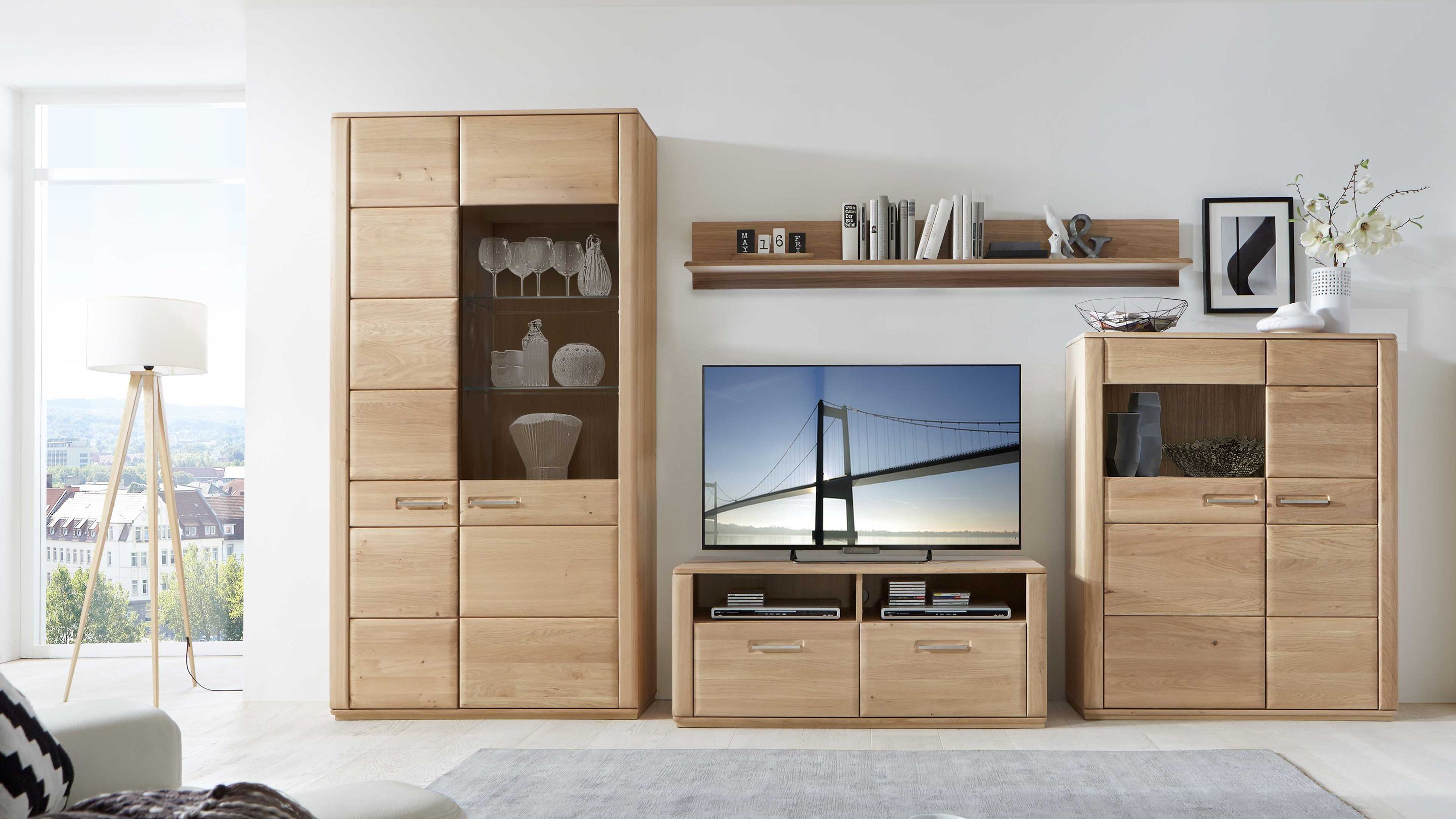 Wohnwand mit Vitrine und TV-Schrank aus hellem Holz Vierteilige Wohnwand aus hellem Holz mit Vitrine TV-Schrank Regalfach und Kommode in modernem Wohnzimmer