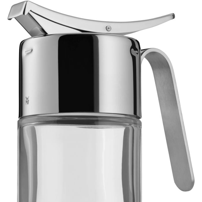 Nahaufnahme eines eleganten Sirup- oder Saucenspenders aus Glas mit glänzendem Edelstahl-Deckel und Griff