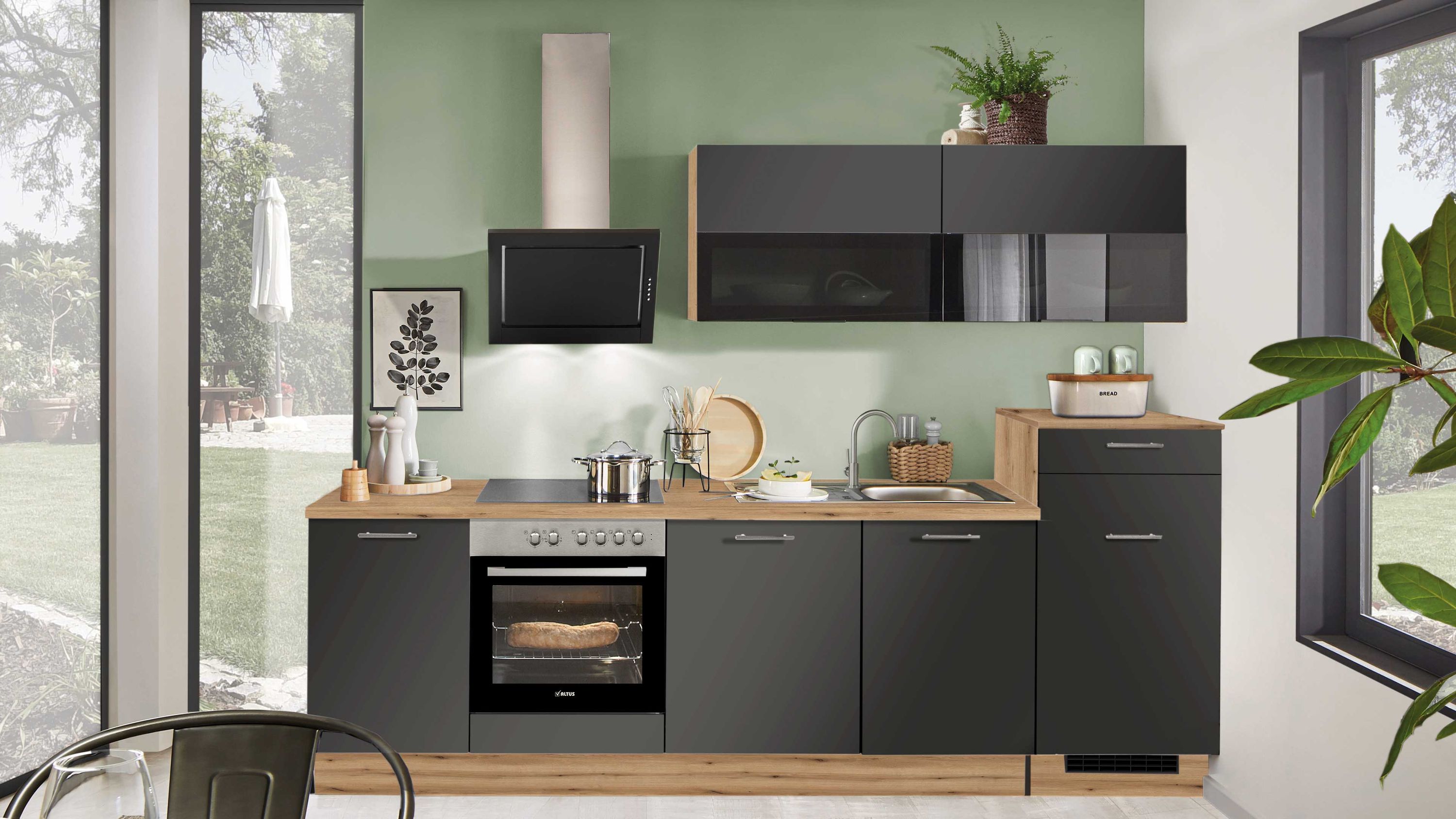 Schwarze Küche mit Holzdetails. Kompakte Küche in Schwarz mit Holzarbeitsplatte und grüner Wandgestaltung.