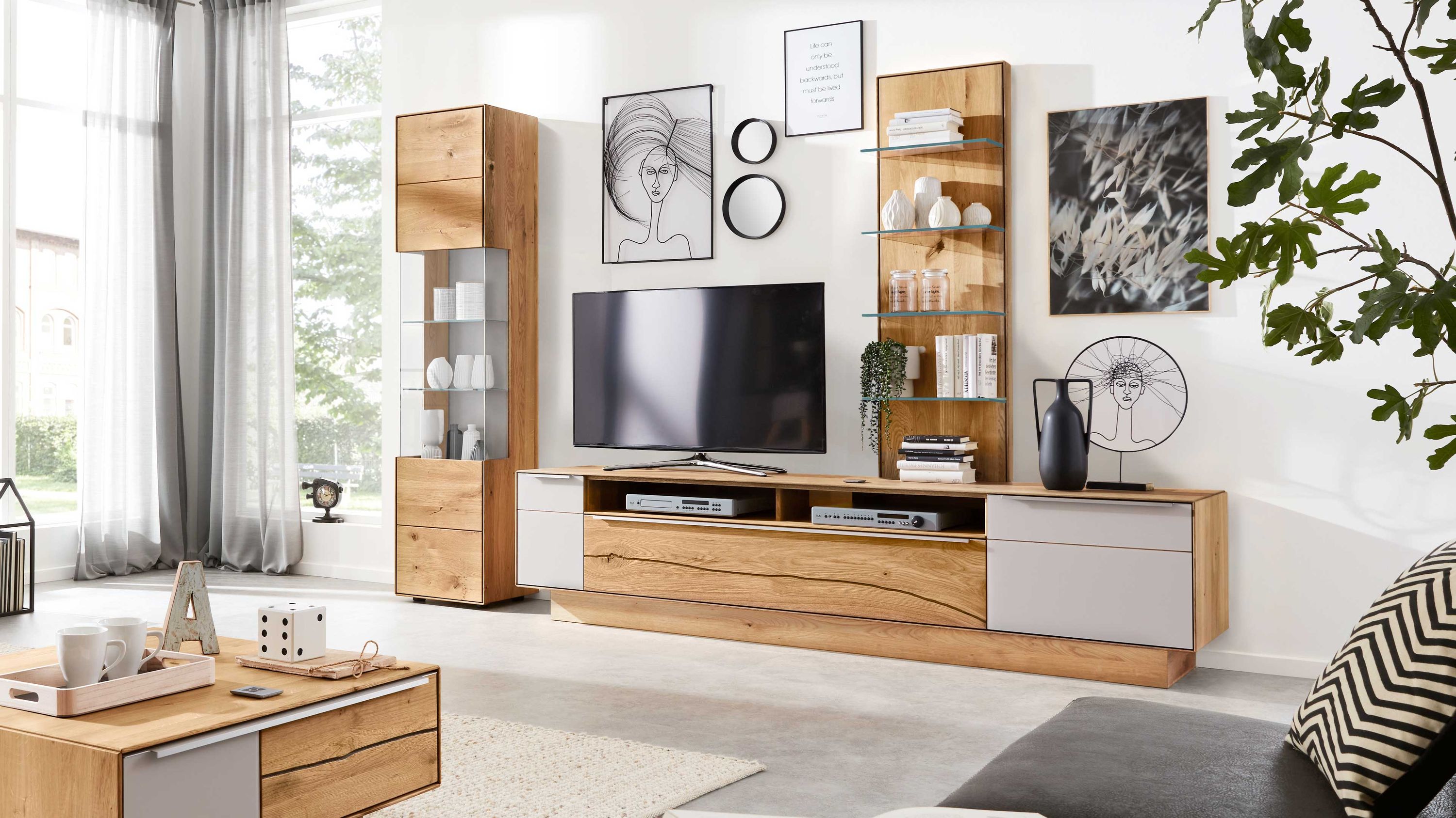 Dreiteilige Wohnwand mit Holzoptik und weißen Fronten Dreiteilige Wohnwand mit Hängeschrank TV-Board und Regal in Holzoptik und weißen Fronten im Wohnzimmer
