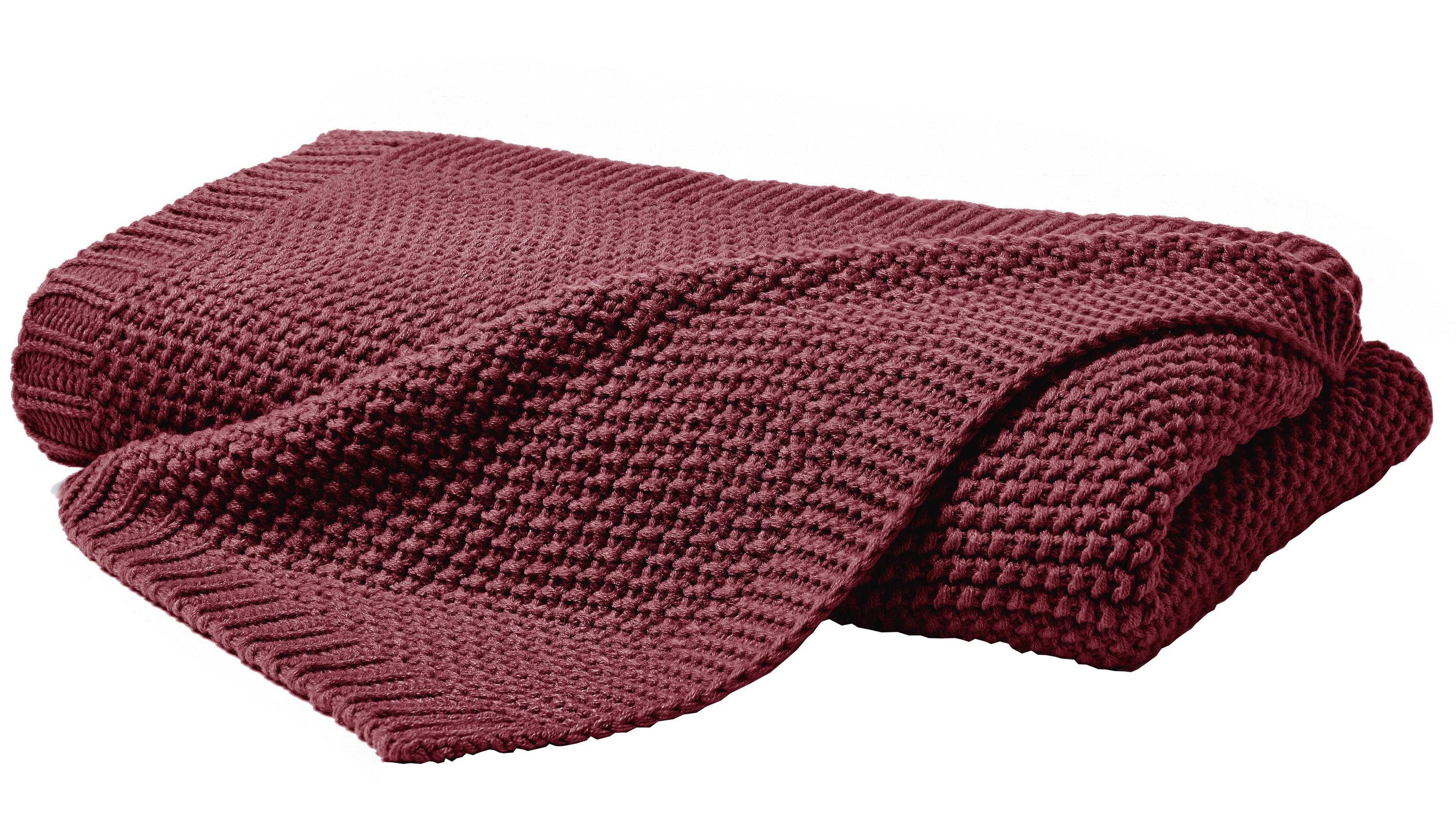 Gefaltete gestrickte Decke in dunklem Rot mit strukturiertem Muster