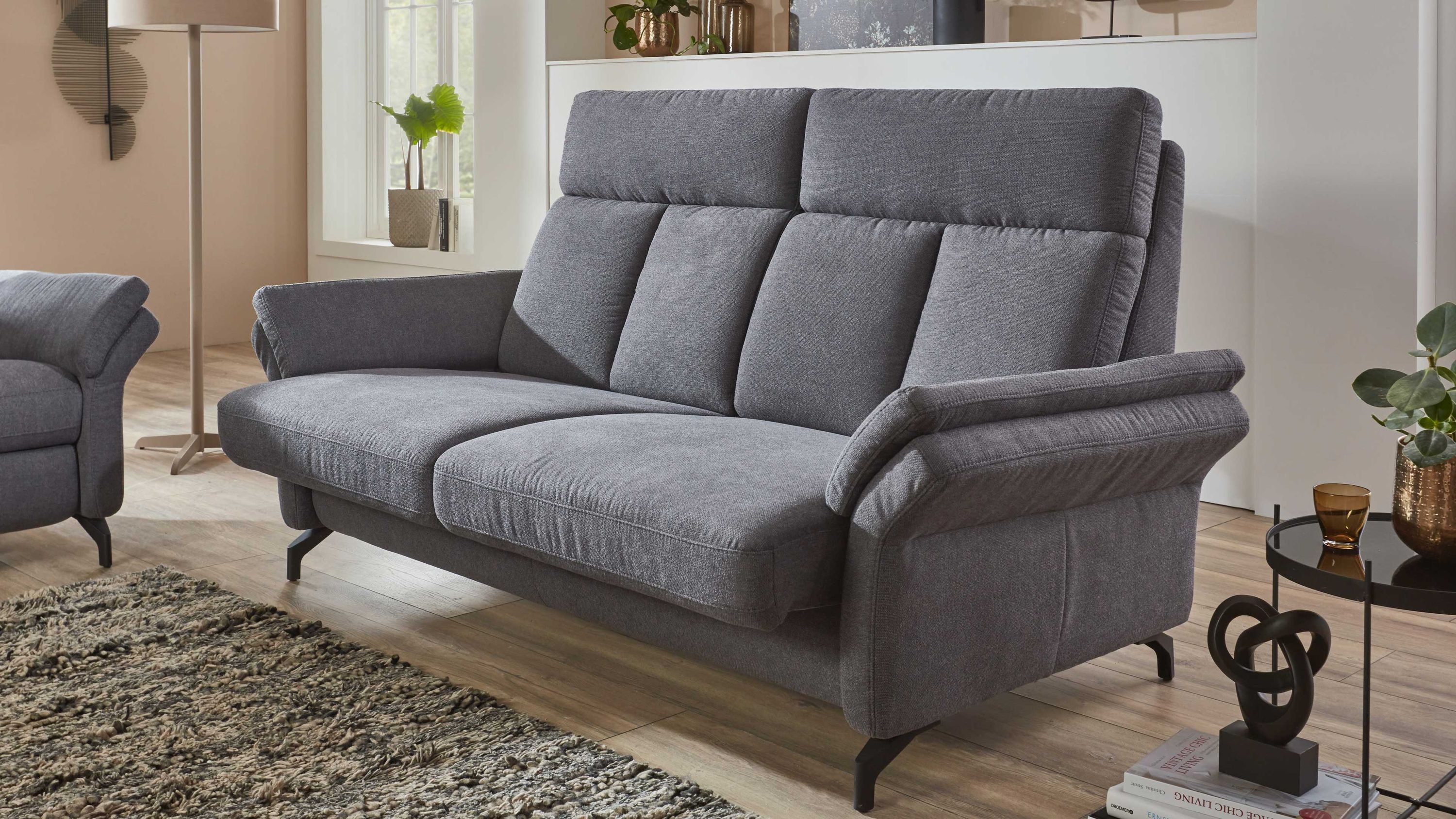 Zweisitziges Sofa mit anthrazitfarbenem Stoffbezug und verstellbarer Sitzfläche