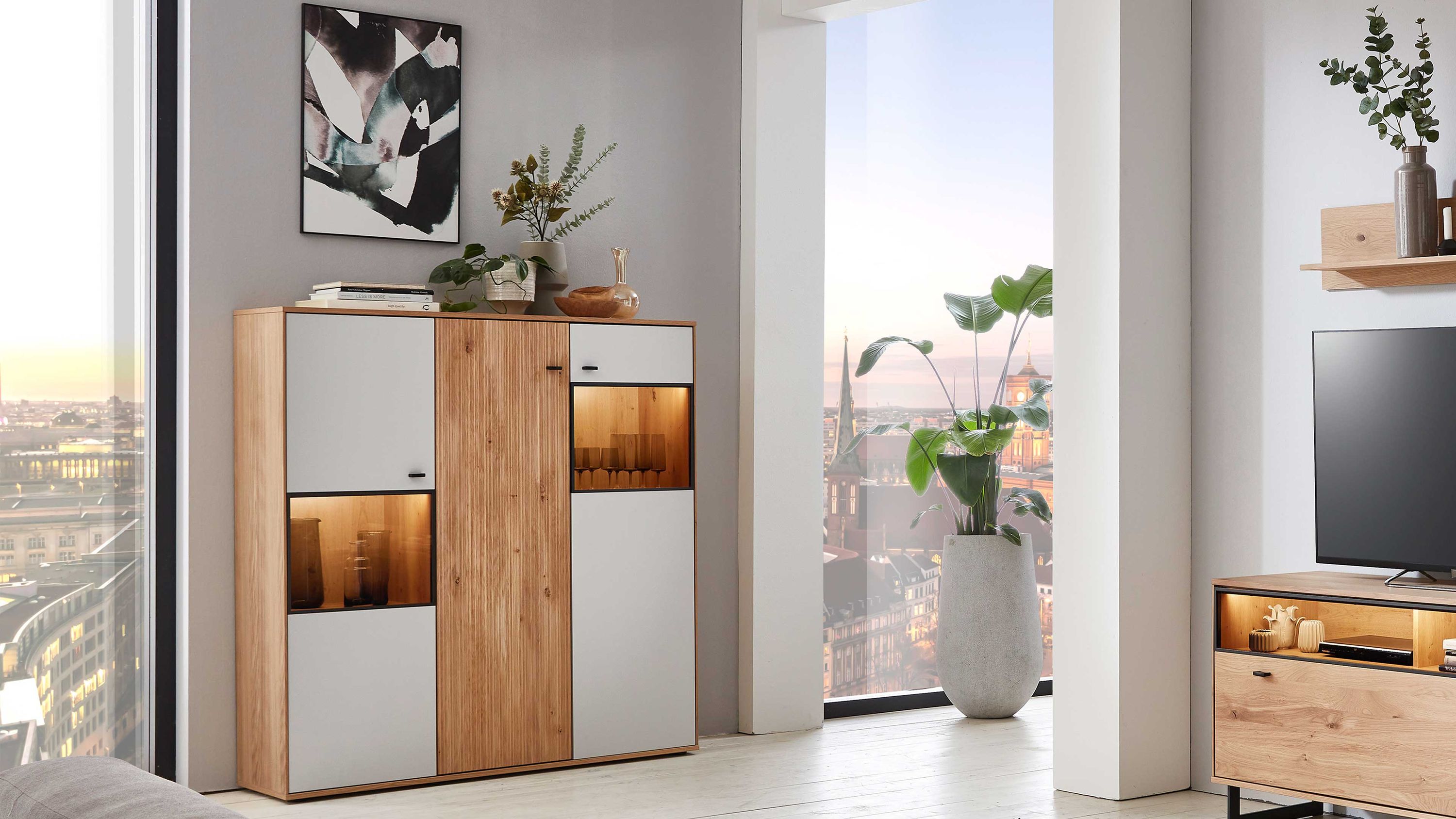 Highboard mit drei Türen in mattweiß und Asteiche Highboard mit drei Türen in mattweiß und Asteiche mit zwei beleuchteten Glasfächern