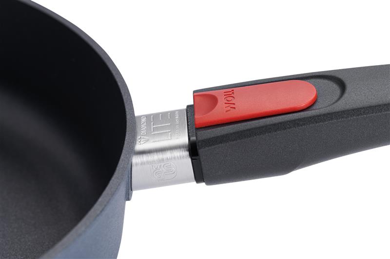Nahaufnahme einer schwarzen Pfanne mit abnehmbarem Griff und rotem Verriegelungsknopf.