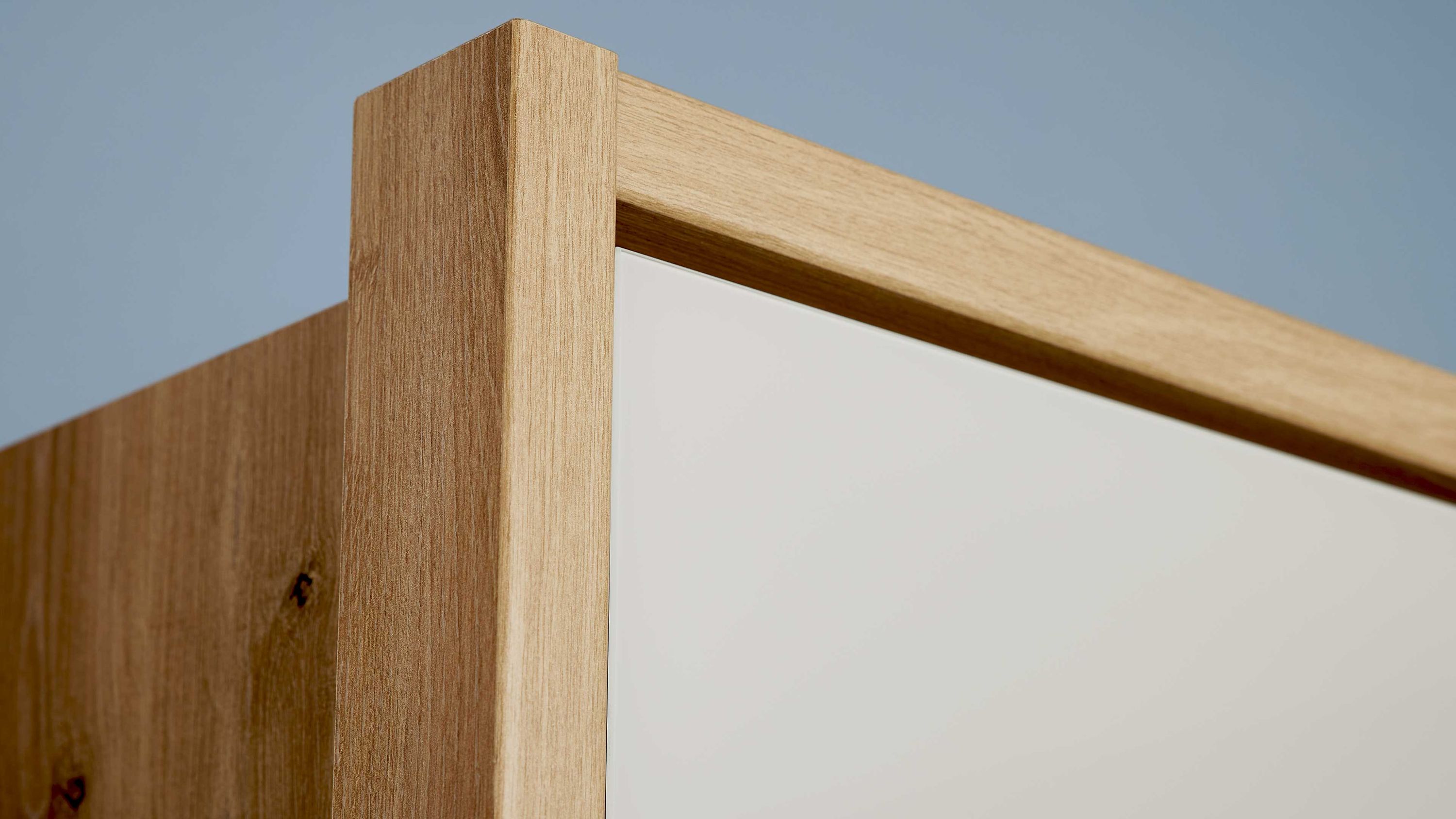 Schrank mit Holzrahmen und weißer Tür Eckansicht eines Schranks mit hellbraunem Holzrahmen und weißer Tür
