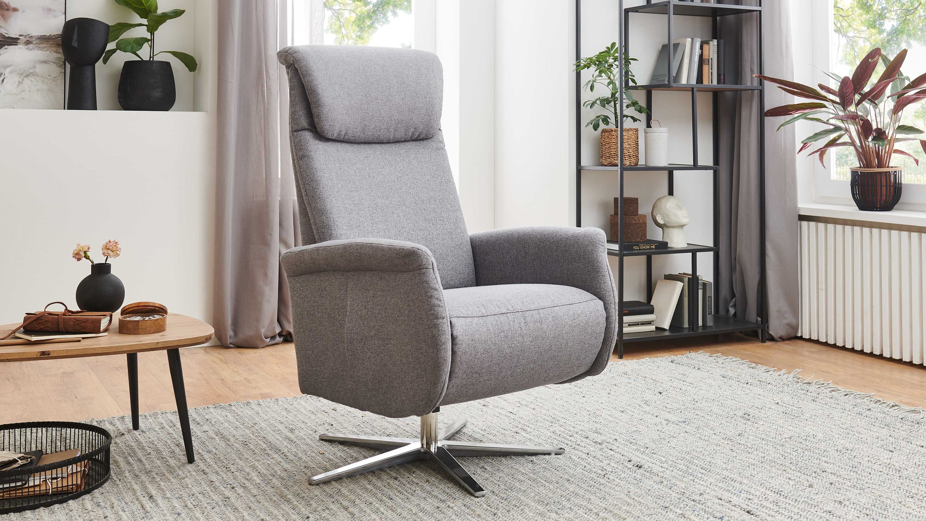 Grauer Relaxsessel mit Metallfuß Grauer Relaxsessel mit hoher Rückenlehne und glänzendem Metallfuß in modernem Wohnzimmer
