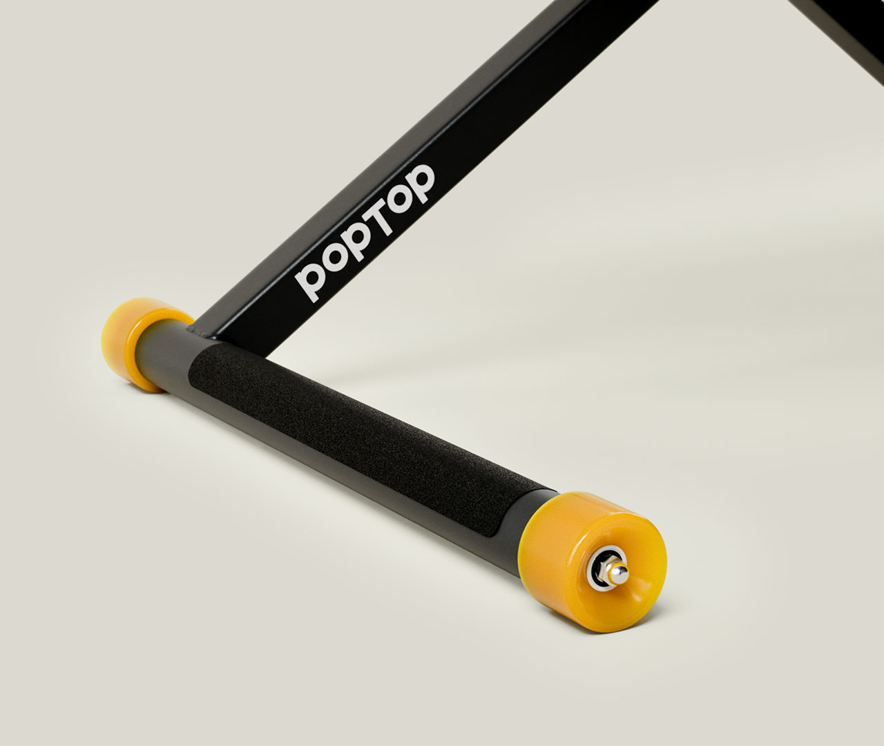 Unterer Bereich eines schwarzen Schreibtischs mit gelben Rollen und sichtbarem Markenaufdruck.