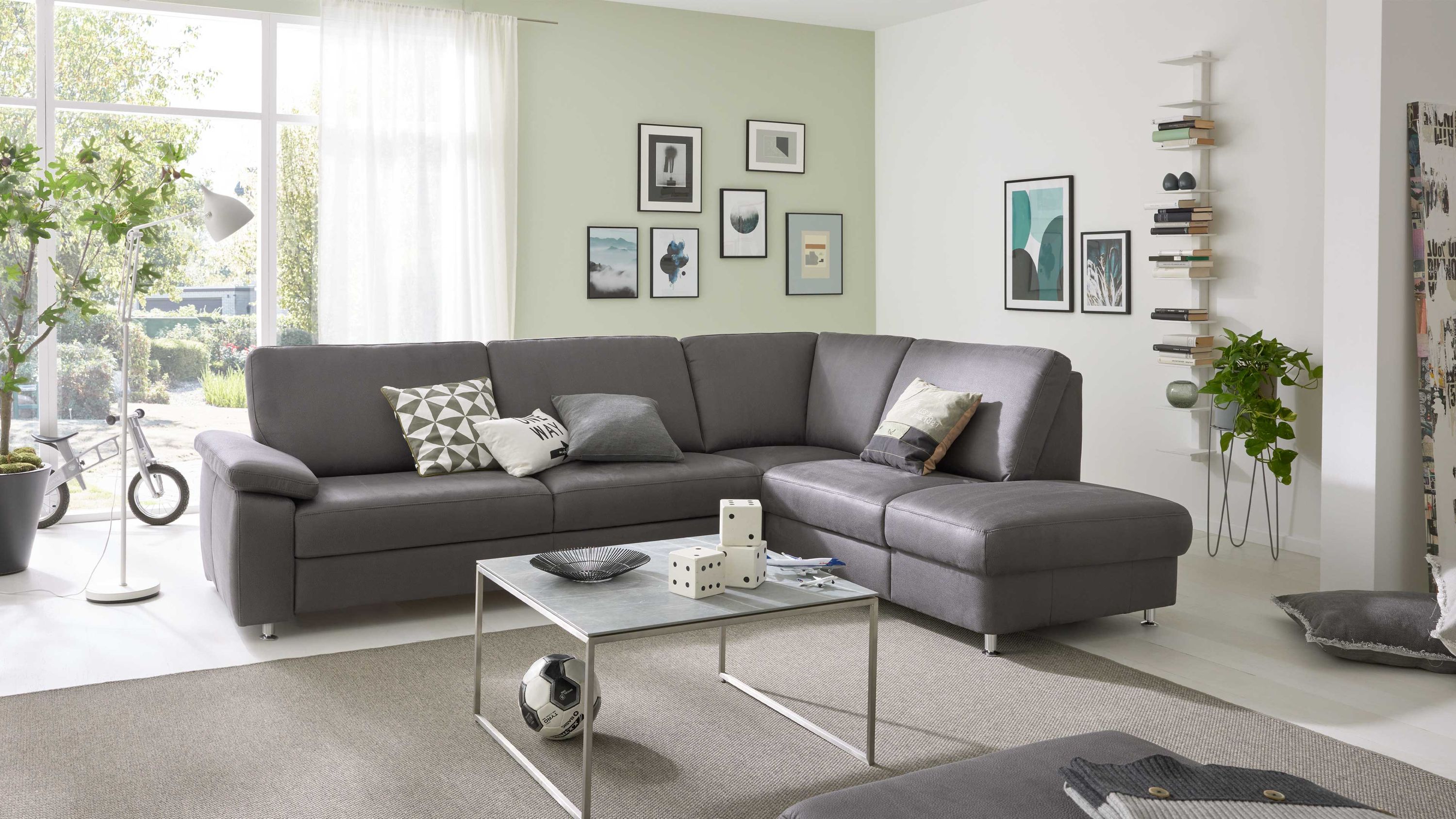 Ecksofa mit stahlfarbener Mikrofaser und matten Metallfüßen in modernem Wohnzimmer mit Kissen