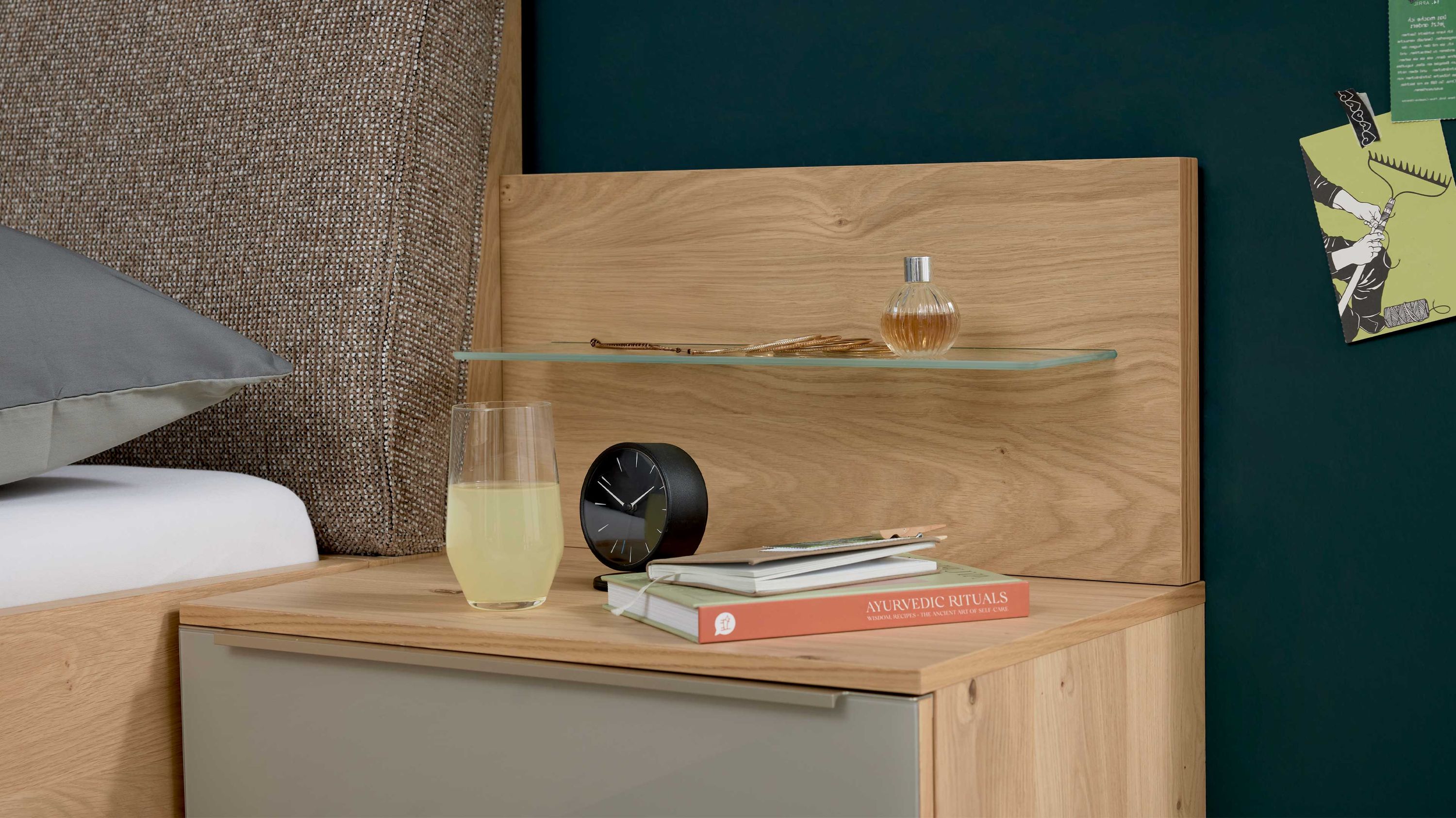 Nachttisch mit rechteckigem Paneelaufsatz in Holzoptik und Glasablage mit Uhr Büchern und Glas darauf