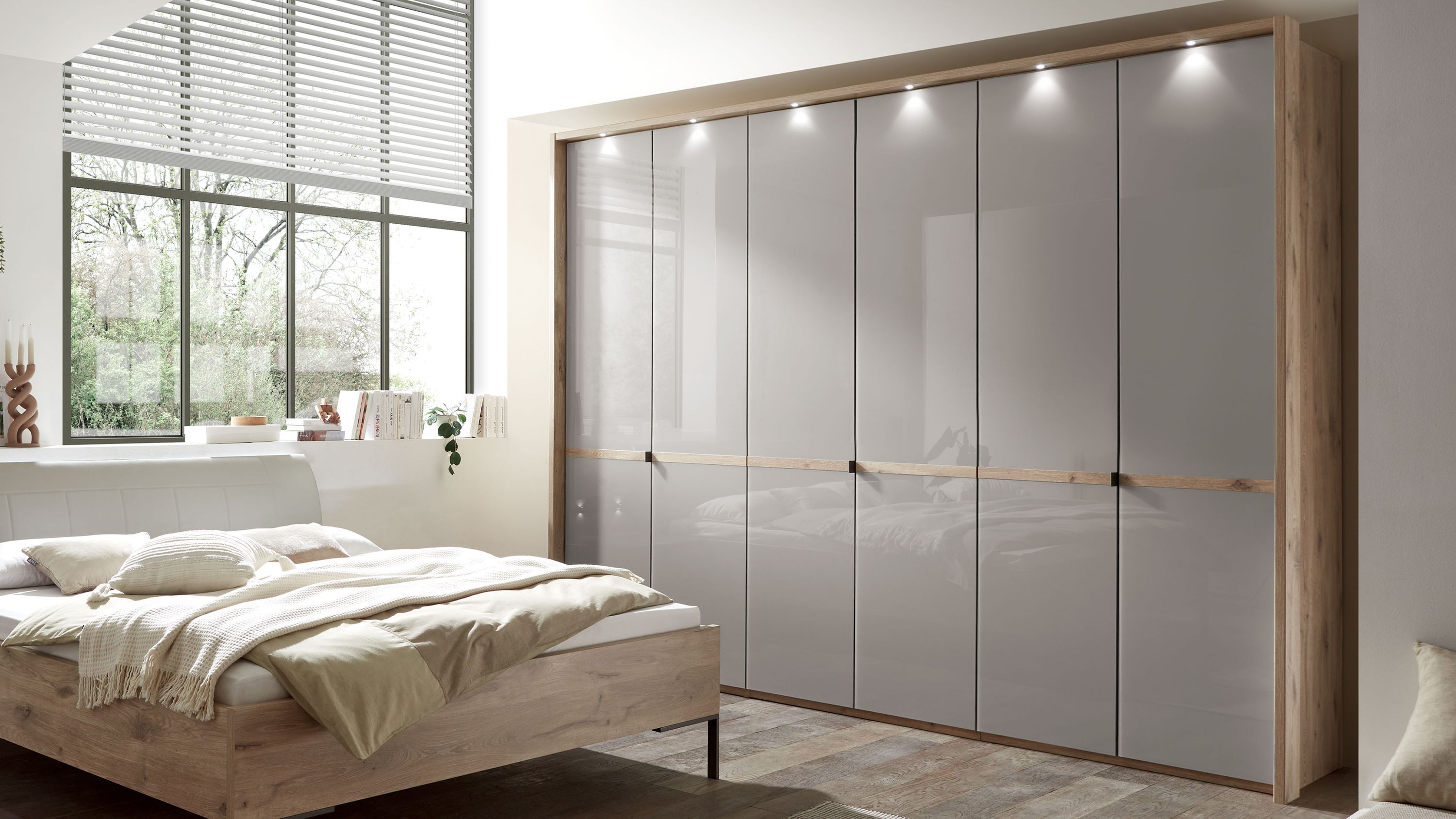 Sechstüriger Kleiderschrank mit kieselgrauen Türen und Rahmen in heller Holzoptik in einem Schlafzimmer