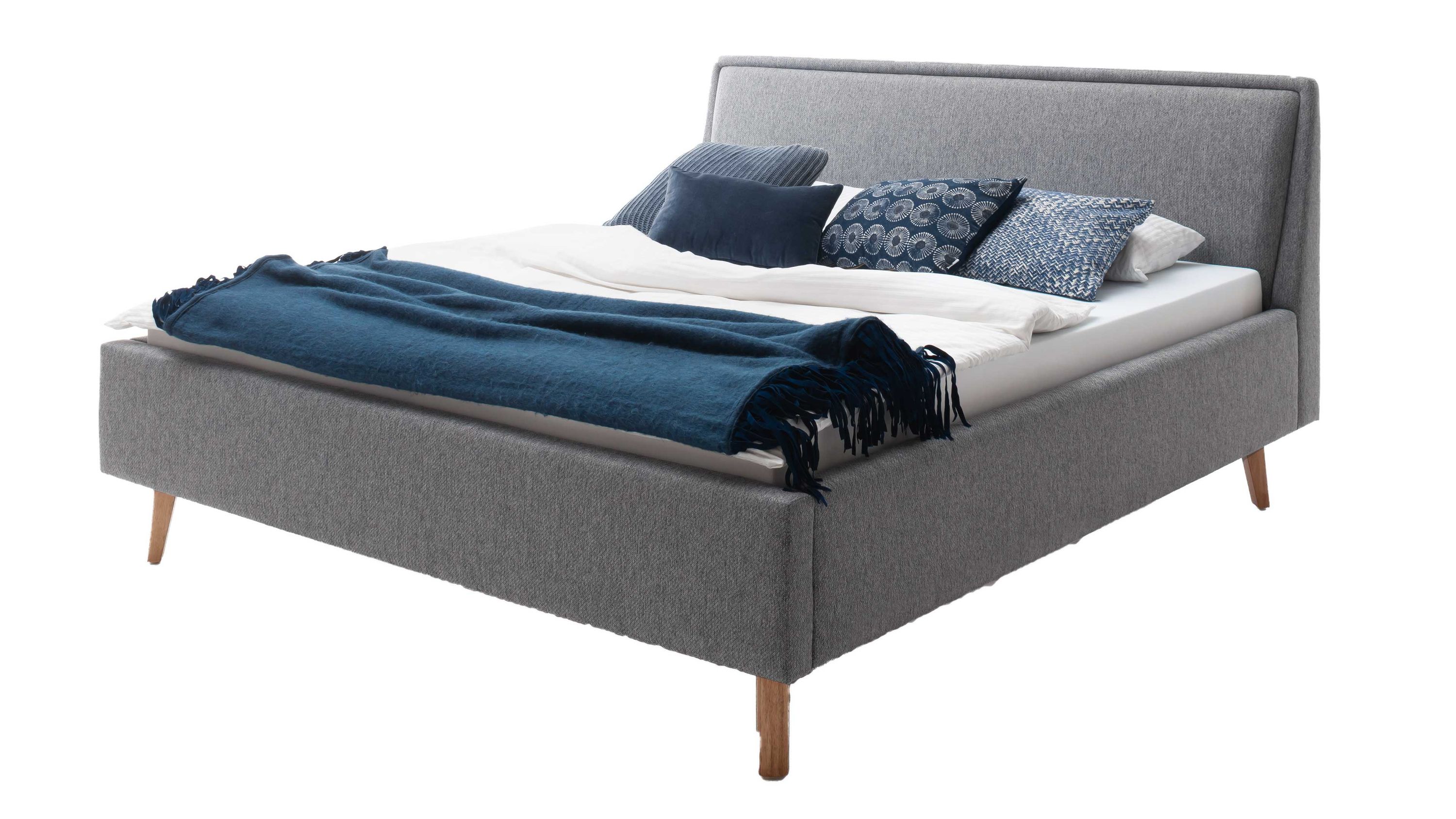 Polsterbettgestell mit grauem Bezug und Holzfüßen Polsterbettgestell mit grauem Bezug eichefarbenen Holzfüßen und Bettkasten mit blauer Decke und Kissen