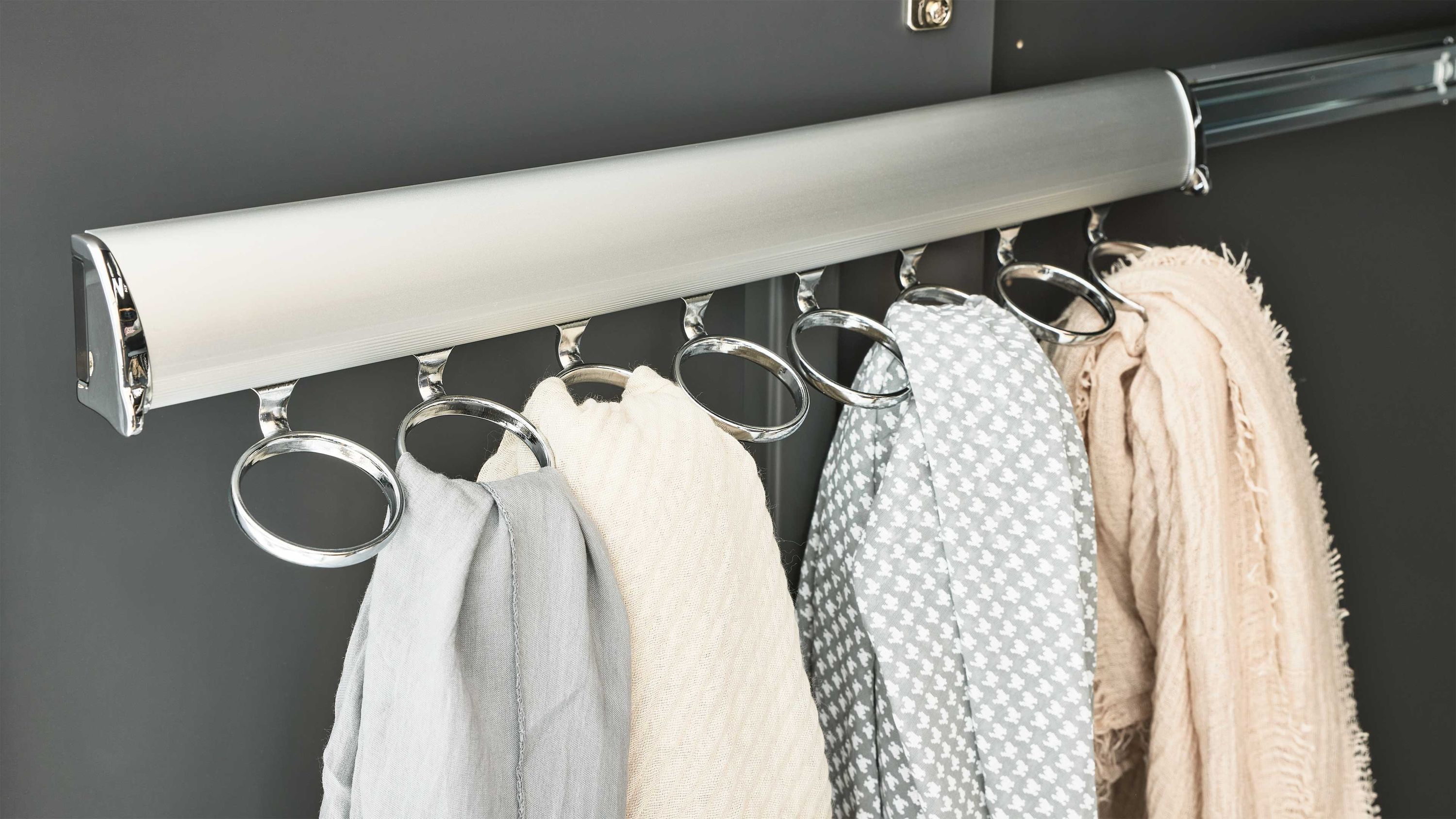 Schalhalter mit acht runden Ösen an einer Wand montiert mit vier Schals in verschiedenen hellen Farben