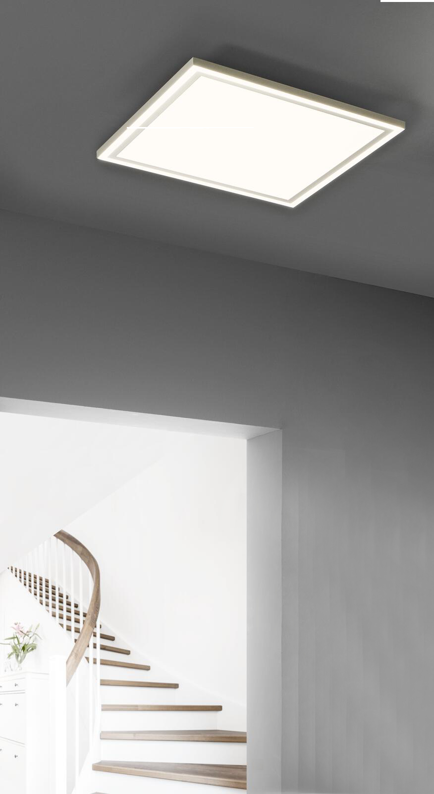 Quadratische LED-Deckenleuchte sanfter Lichtschein an grauer Decke im Hintergrund Treppe mit Holzstufen