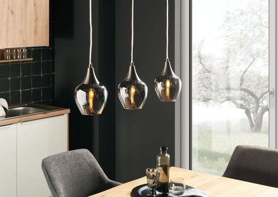 Drei Pendelleuchten mit satiniertem Glasschirm und Aluminiumabschluss  schräg inszeniert über Esstisch im Wohnambiente