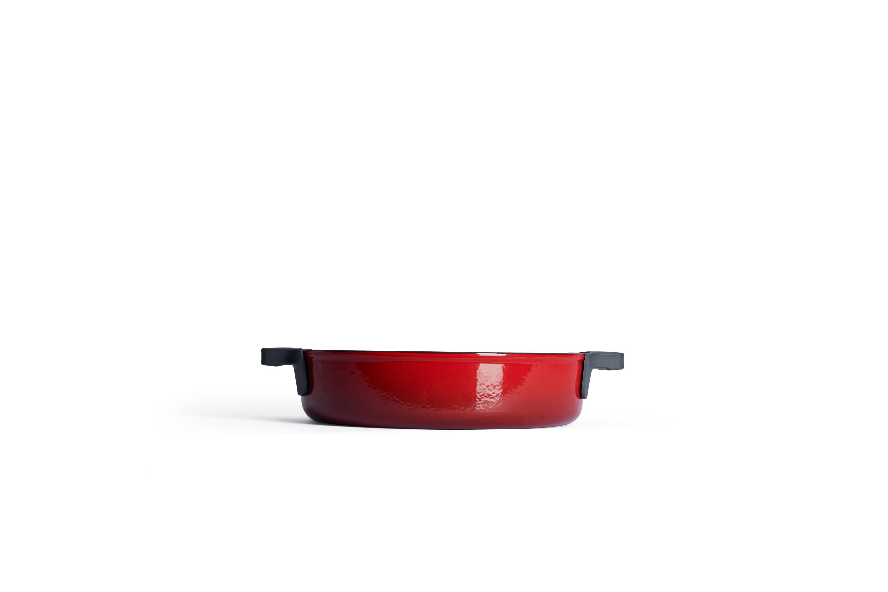 Chilli-roter Kochtopf ohne Deckel mit seitlichen Silikongriffen frontal auf heller Oberfläche