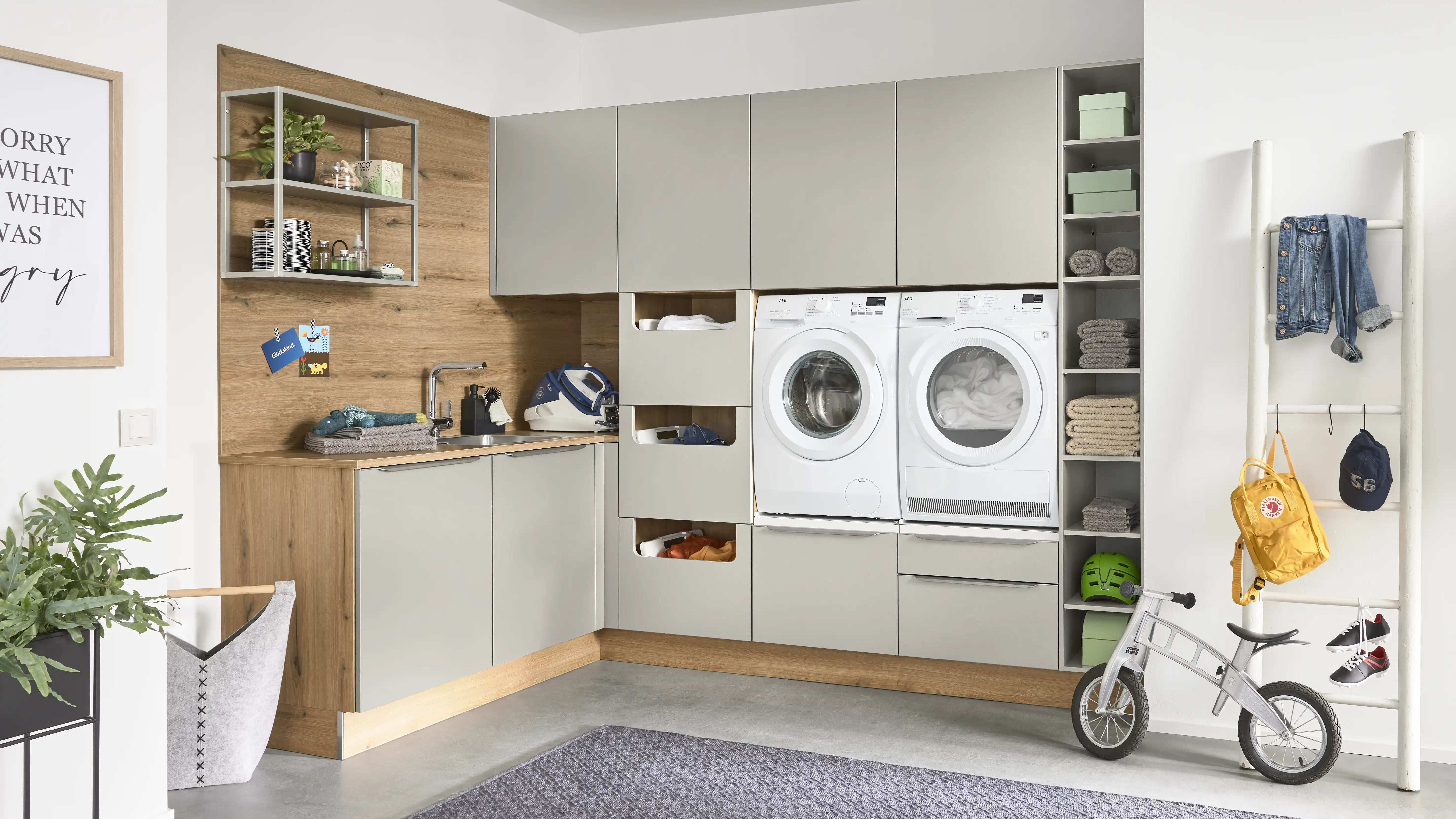 Großzügiger Hauswirtschaftsraum mit Waschmaschine, Trockner, Regalen, Vorratsaufbewahrung und Fahrrad