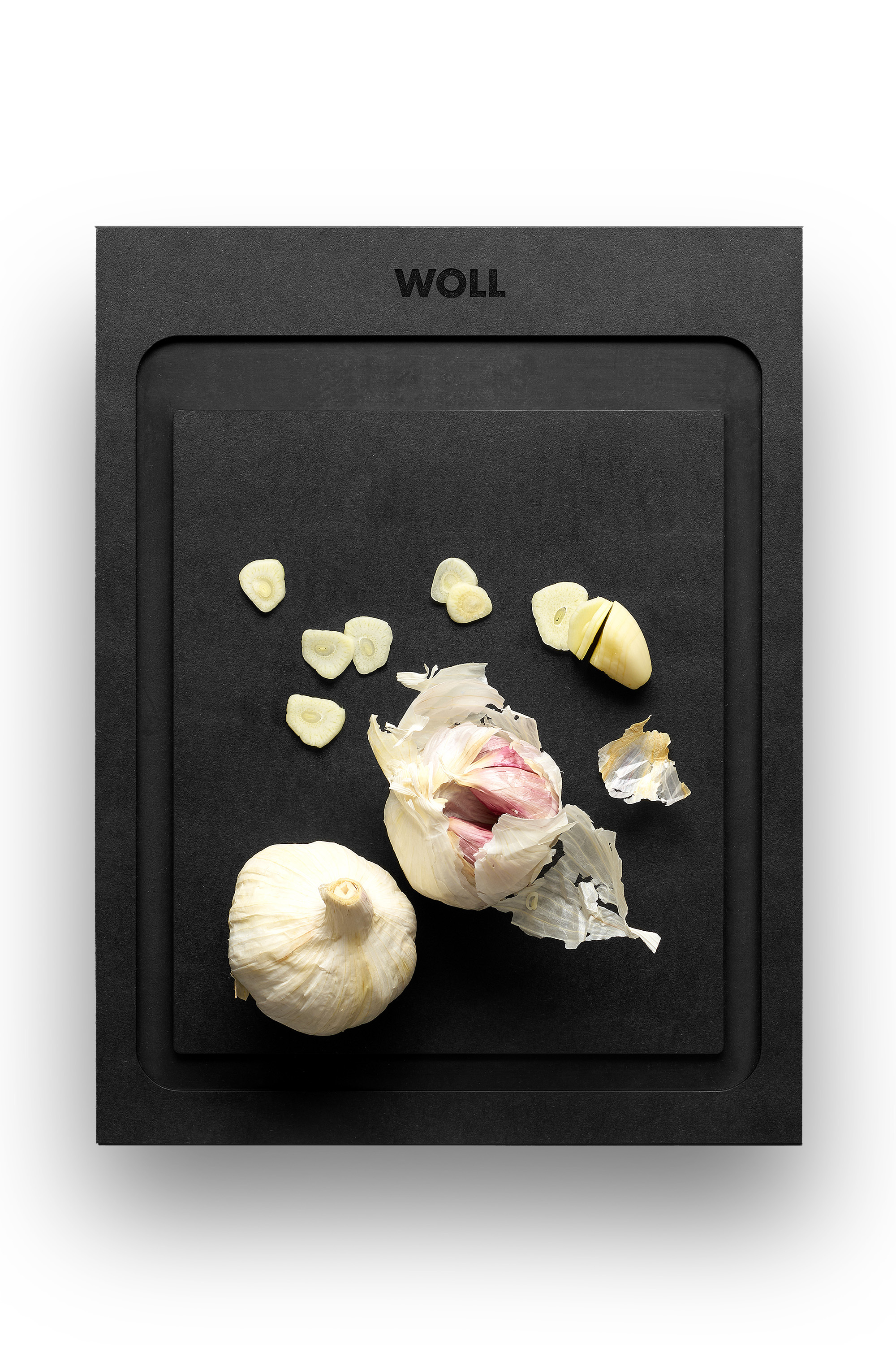WOLL-Schneidebrett mit geschnittenem und ungeschältem Knoblauch.