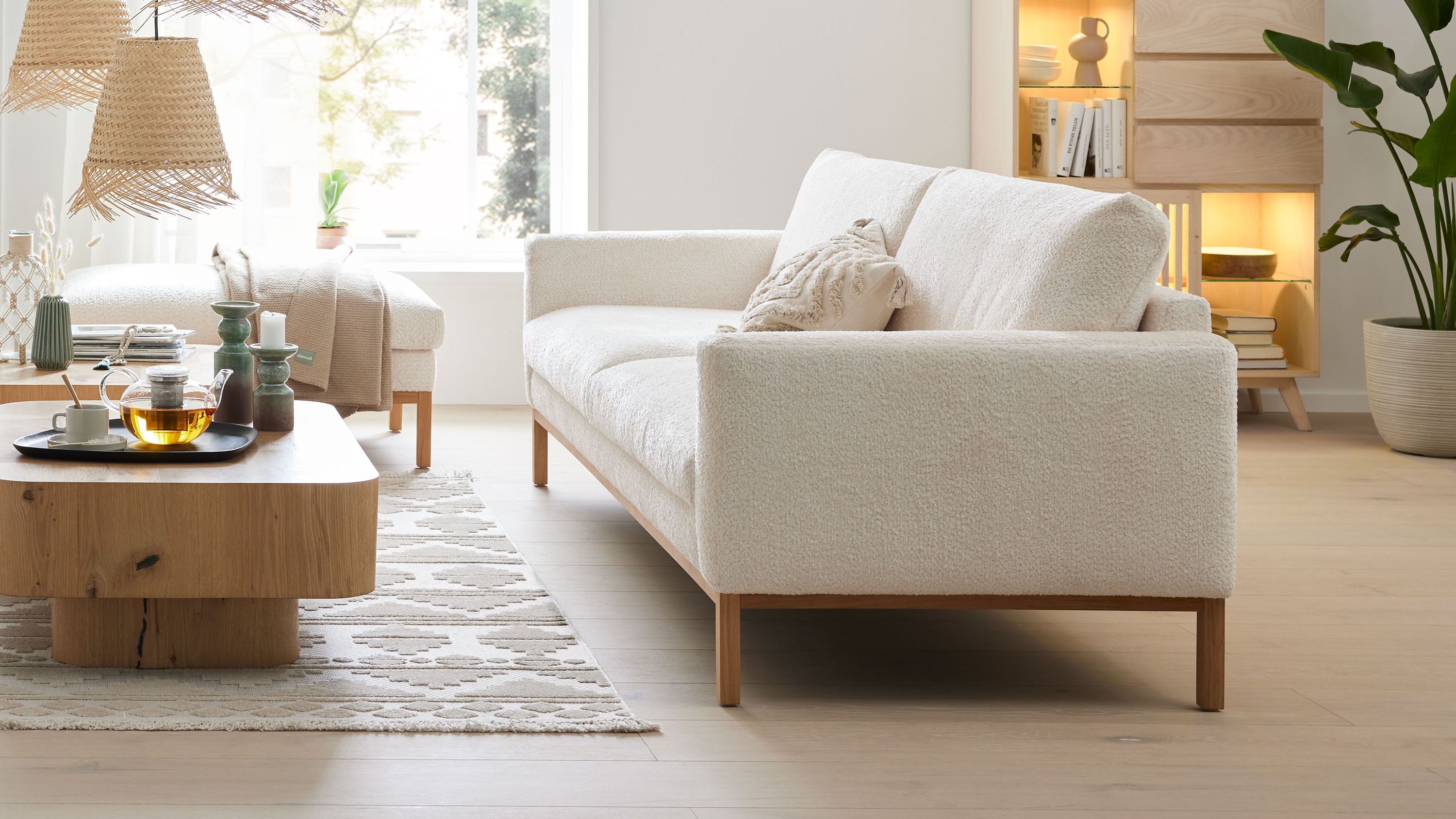 Zweisitziges Sofa mit weißem Stoffbezug und Holzfüßen in modernem Wohnzimmer