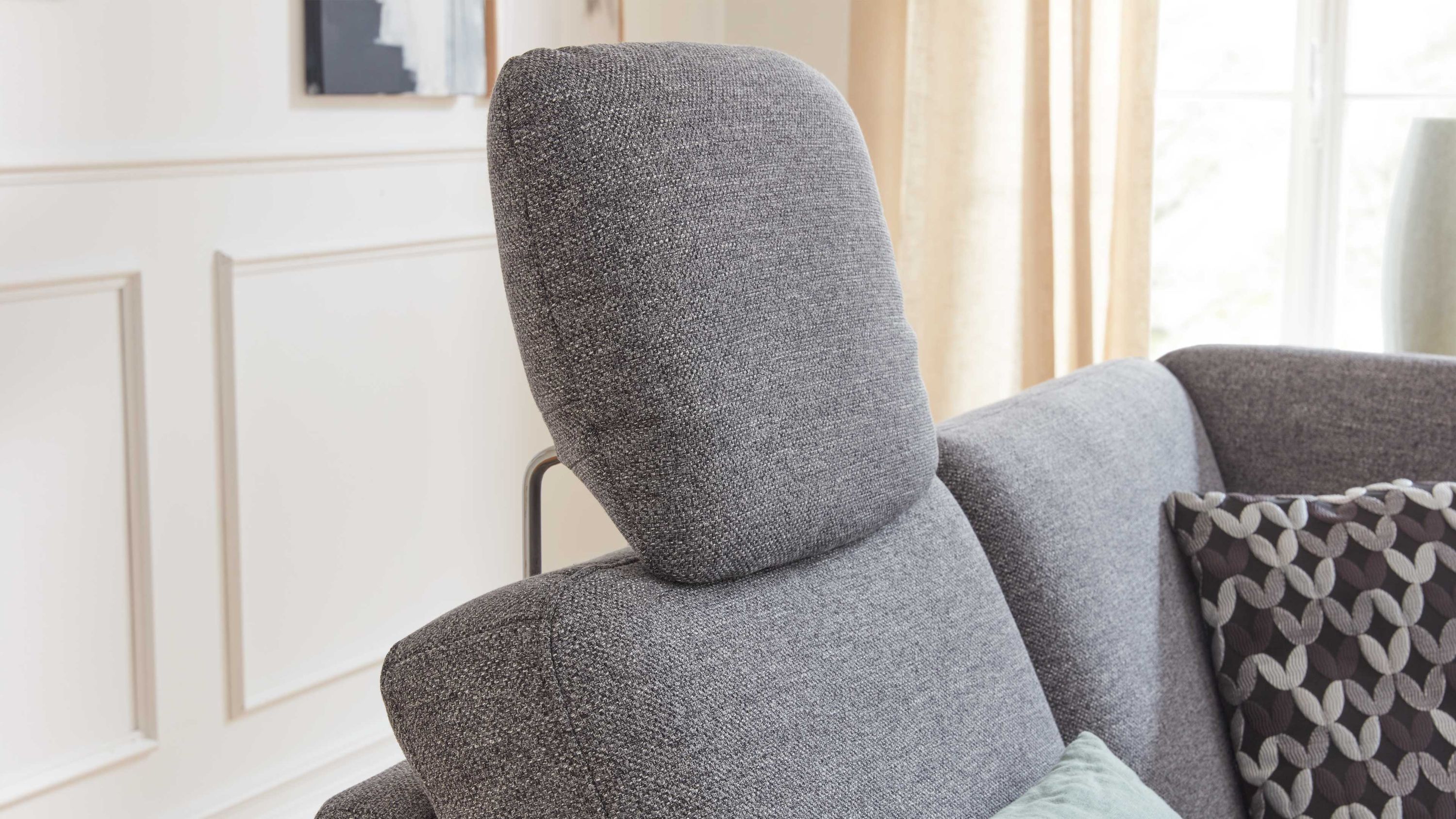 Stahlgraue gepolsterte Kopfstütze aus Flachgewebe auf einem Sofa mit grauem Stoffbezug