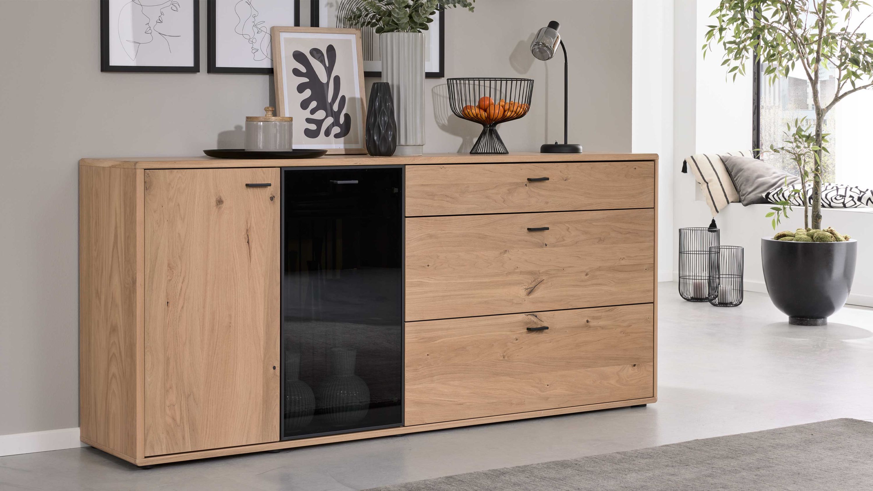 Sideboard mit zwei Türen und drei Schubladen in Holzoptik und schwarzem Glas in modernem Wohnzimmer