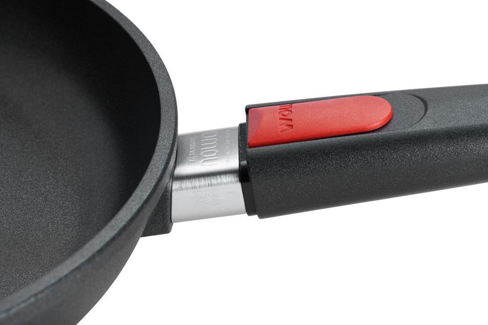 Schwarze Gusspfanne aus Aluminium mit Titan-Beschichtung abnehmbarem Griff und rotem Knopf schräg von oben