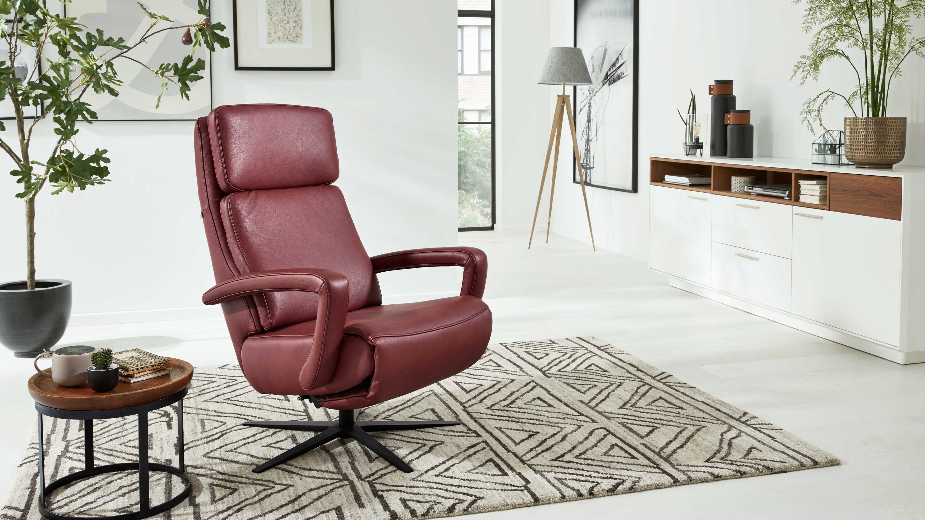 Relaxsessel mit hoher Rückenlehne und Armlehnen in rot auf Sternfuß in modernem Wohnzimmer