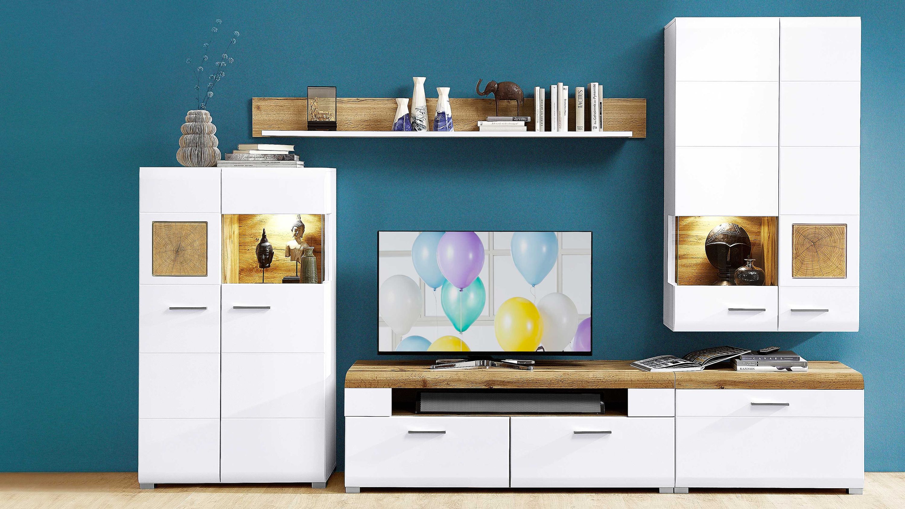 Fünfteilige Wohnwand mit weißen Fronten und Holzdekor bestehend aus zwei hohen Schränken einem TV-Board und einem Wandregal
