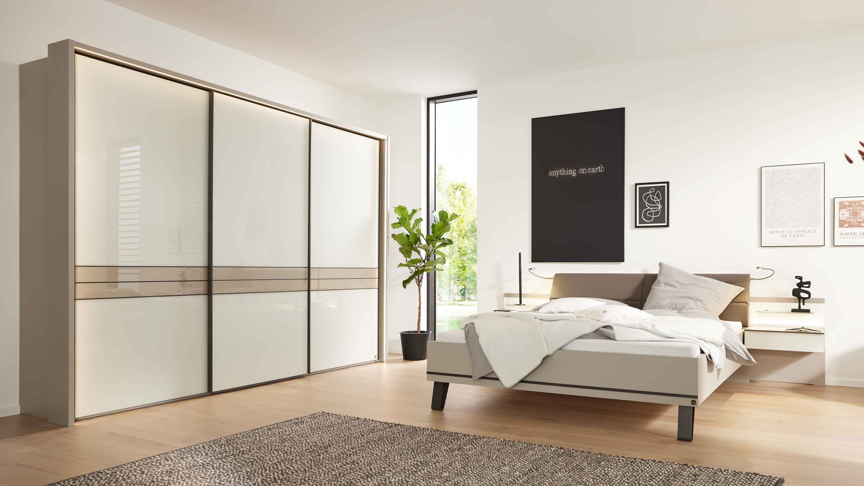 Schlafzimmer mit weißem Bett grauem Kopfteil zwei Nachttischen und großem Schwebetürenschrank in Weiß und Grau