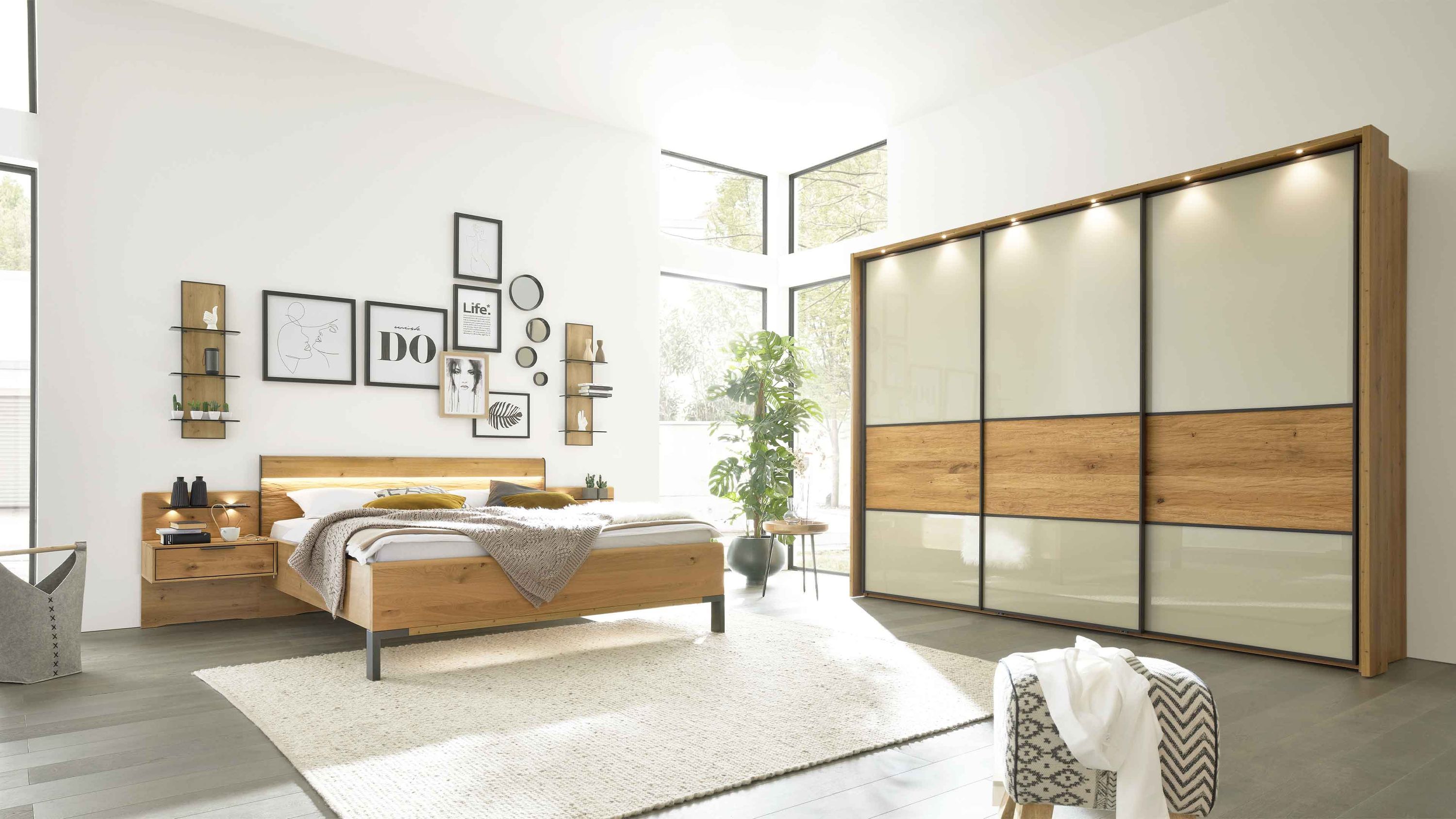 Schlafzimmer mit Holzbett zwei Wandregalen Nachttisch und großem Schiebetürenschrank in Holz und beige