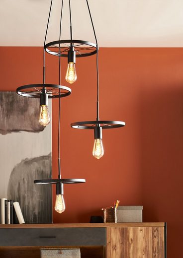 Pendelleuchte mit zylindrischem Leuchtenkörper aus schwarzem Aluminium  seitlich inszeniert über Esstisch im Wohnambiente
