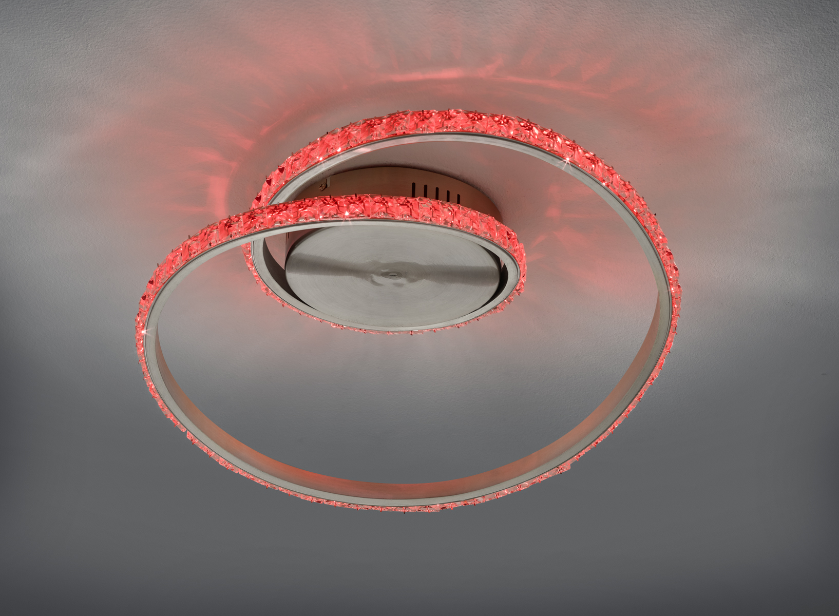 Moderne Deckenleuchte spiralförmiges LED-Design leuchtet Rot erzeugt stimmungsvolles Lichtbild leicht schräg von unten