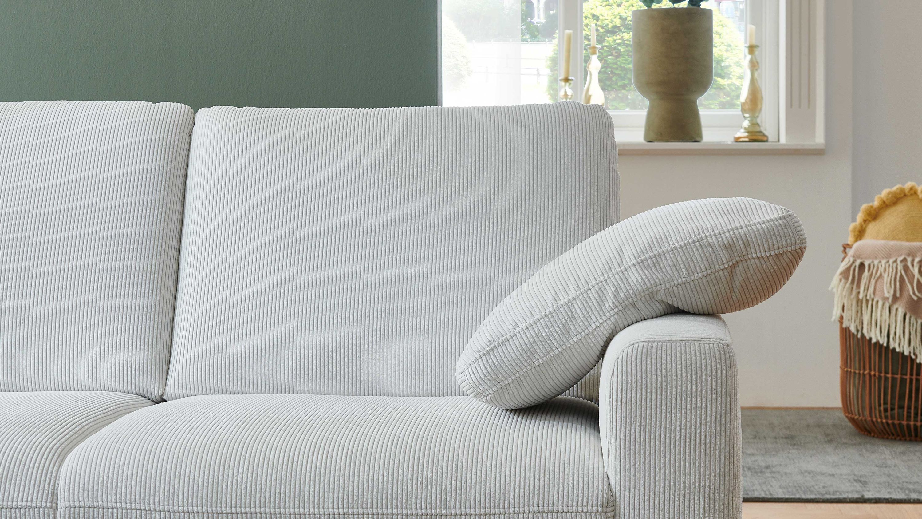 Armlehnkissen aus naturweißem Feincord auf einem Sofa mit geraden Armlehnen